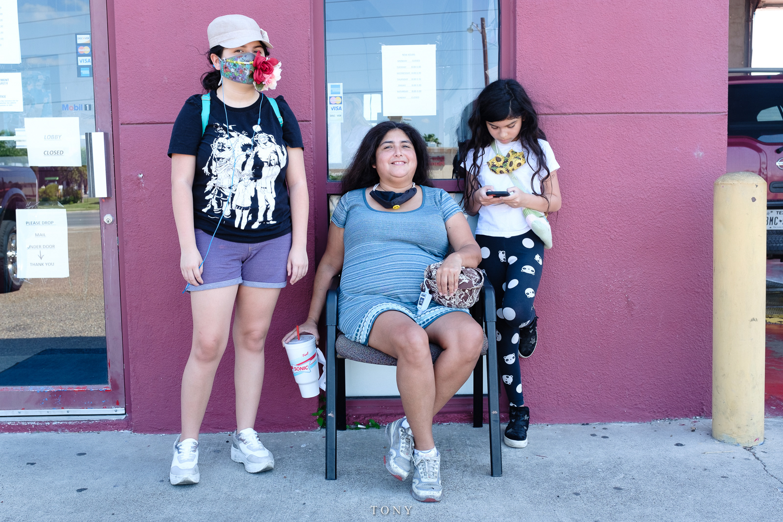 A mother and her daughters wait for an oil change, McAllen, Texas, August 2020.