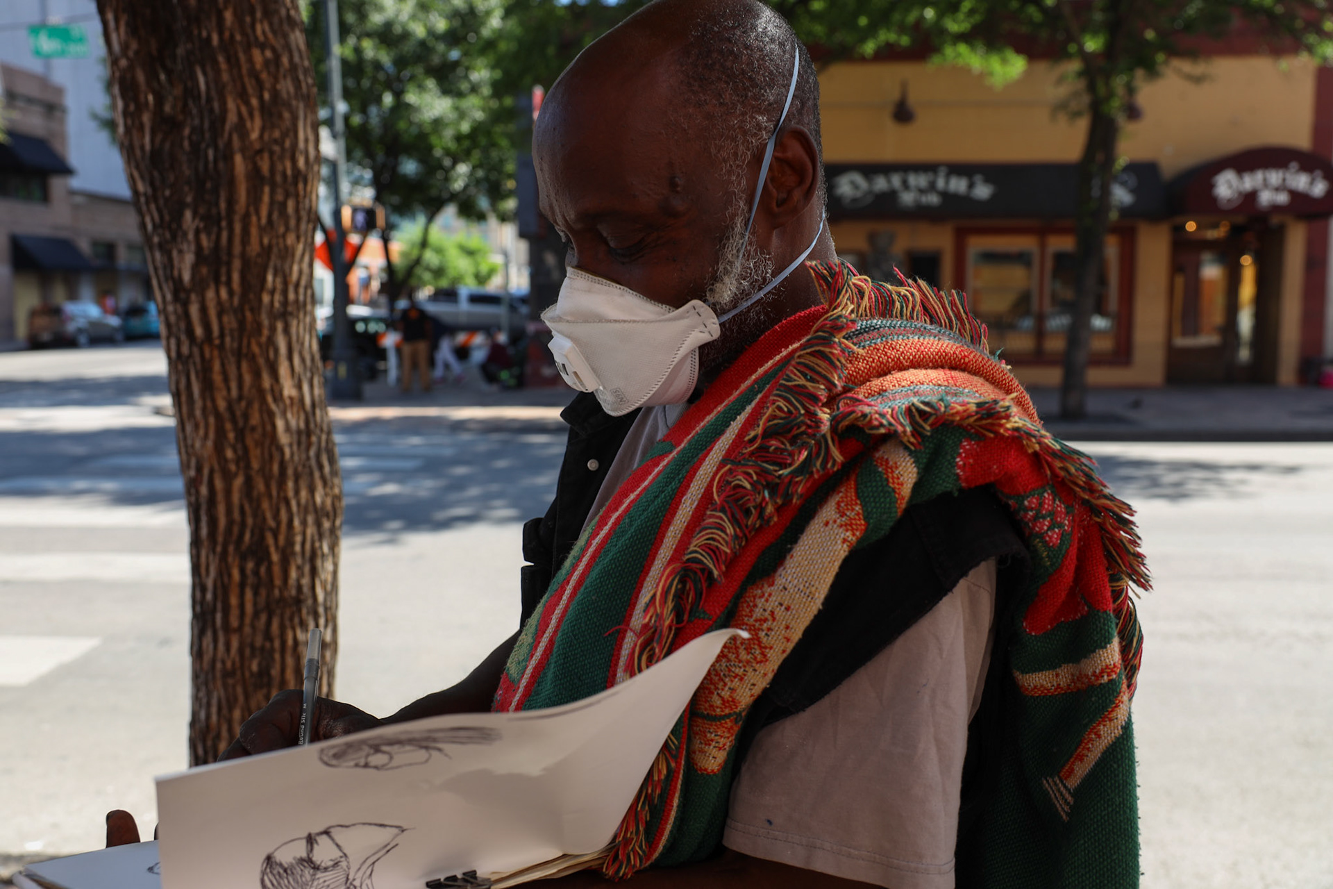 Art Randle quickly sketches two young artists as they work on murals in Sixth Street. Art Randle said he lived down here for many years and wouldn't want to be anywhere else, even during a pandemic.