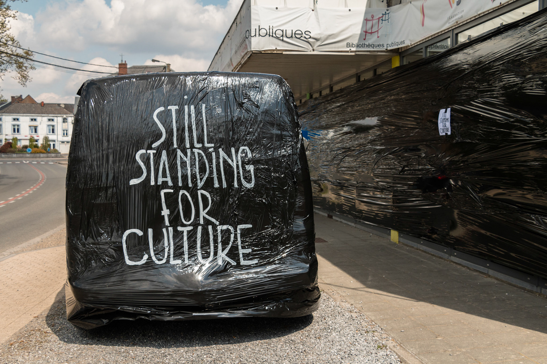 1mai2021 - Florennes - Foyer culturel de Florennes - manifestation du secteur culturel qui revandique le droit de travailler suite à la crise COVID - emballage du batiment et de la camionette avec de la bâche à ballot - la culture est en deuil.