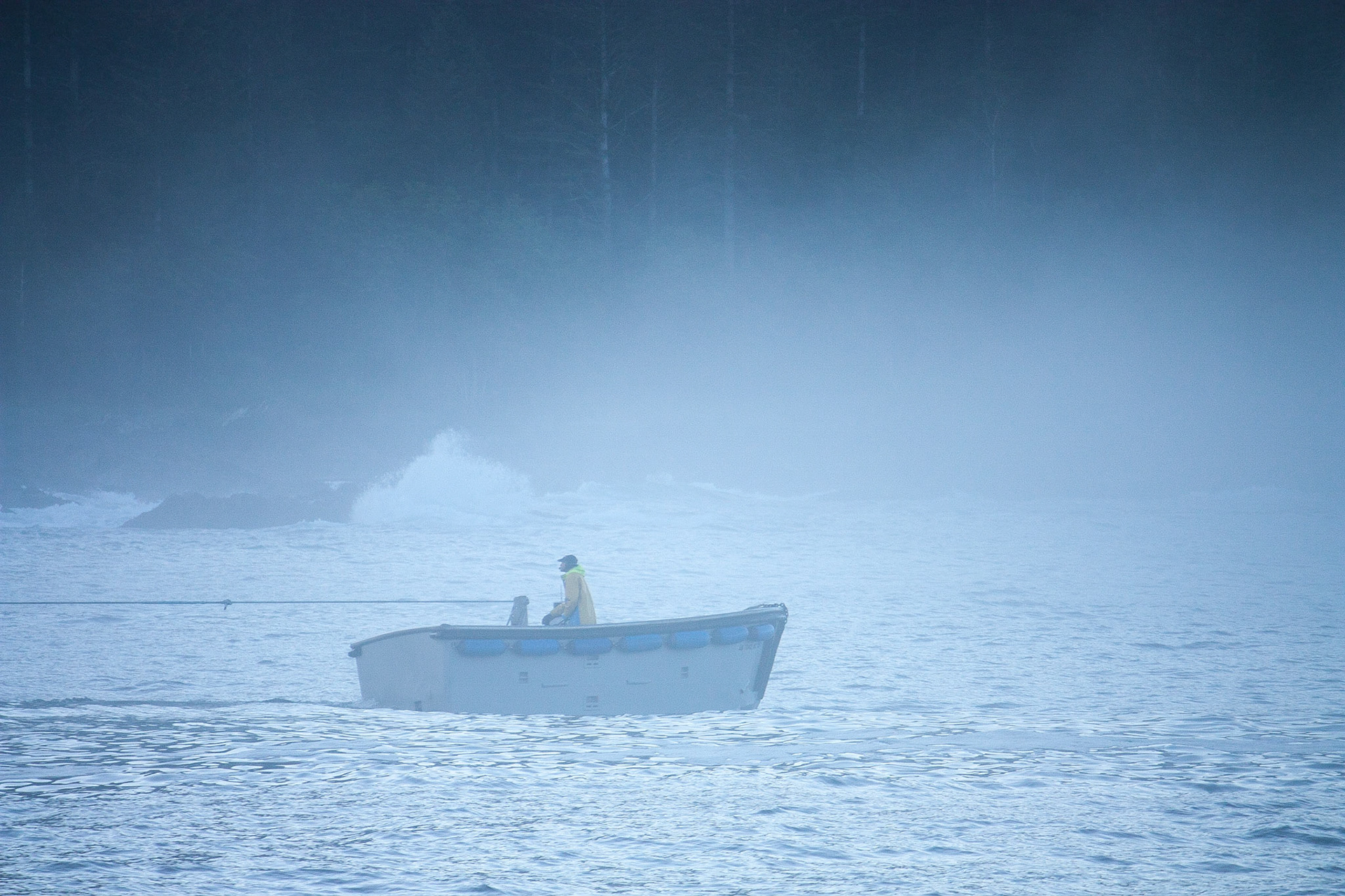 A skiff from a seiner works in the fog off the coast of Baranoff Island in Southeast Alaska, USA.