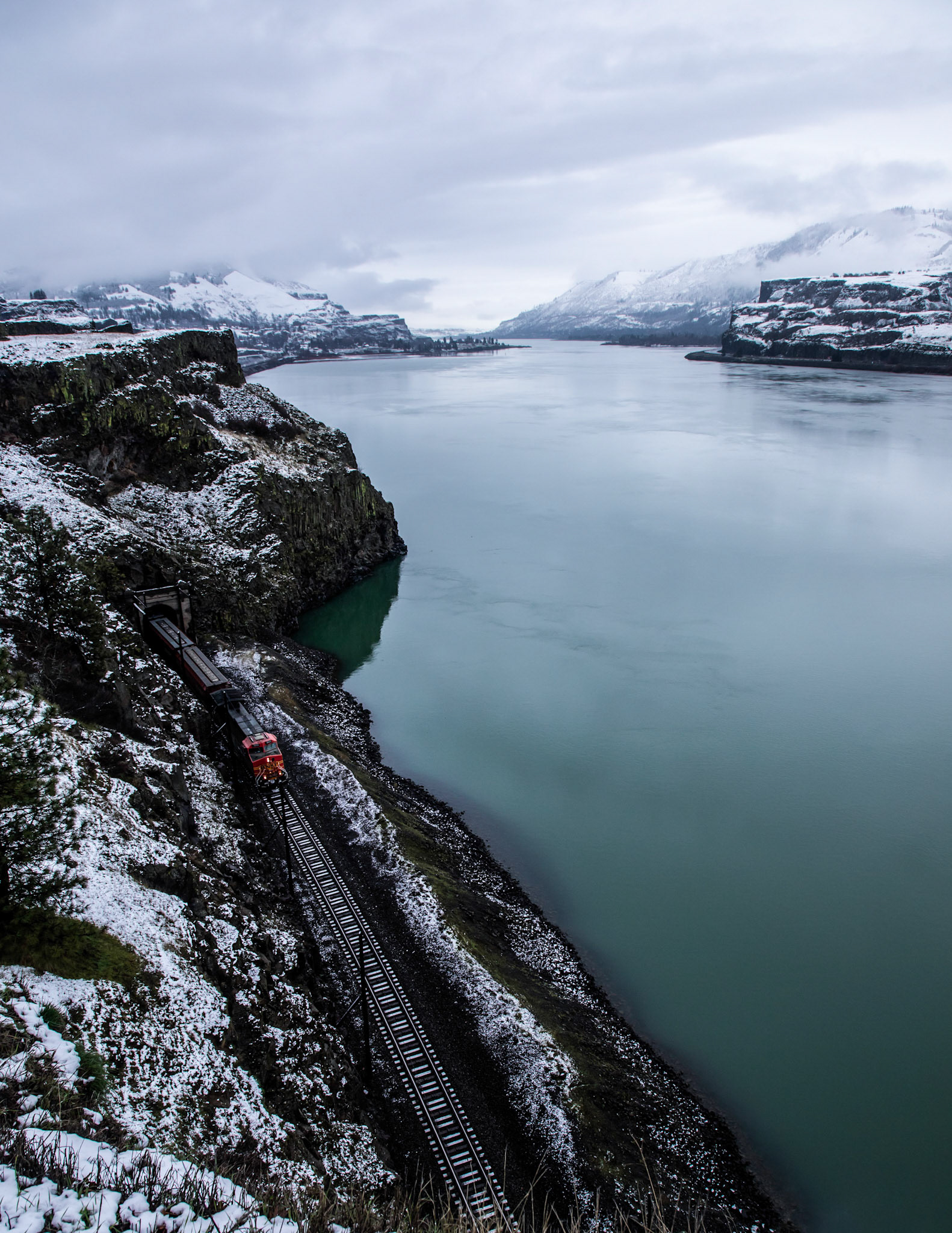 A train travels along the Columbia River in Winter.