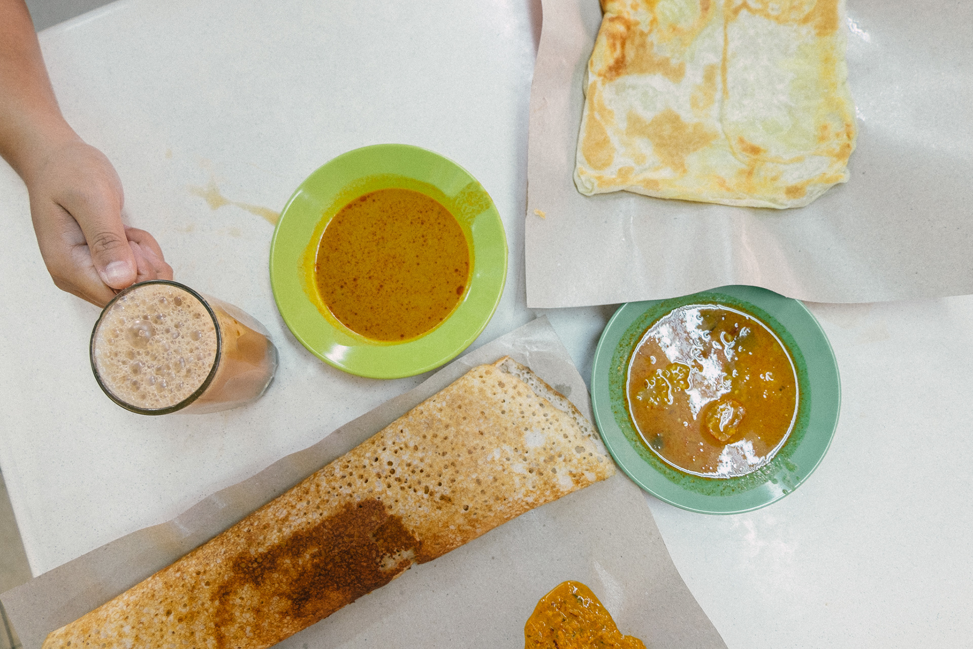 Roti with curry soup and cold milk tea