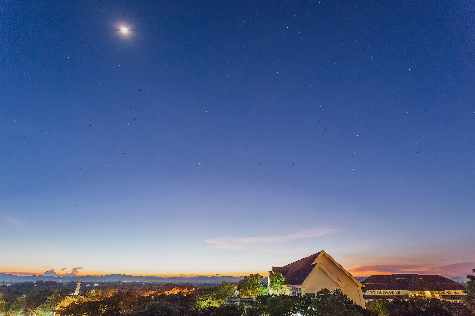 The atmosphere of the university where buildings and nature can be seen from a high angle at night.