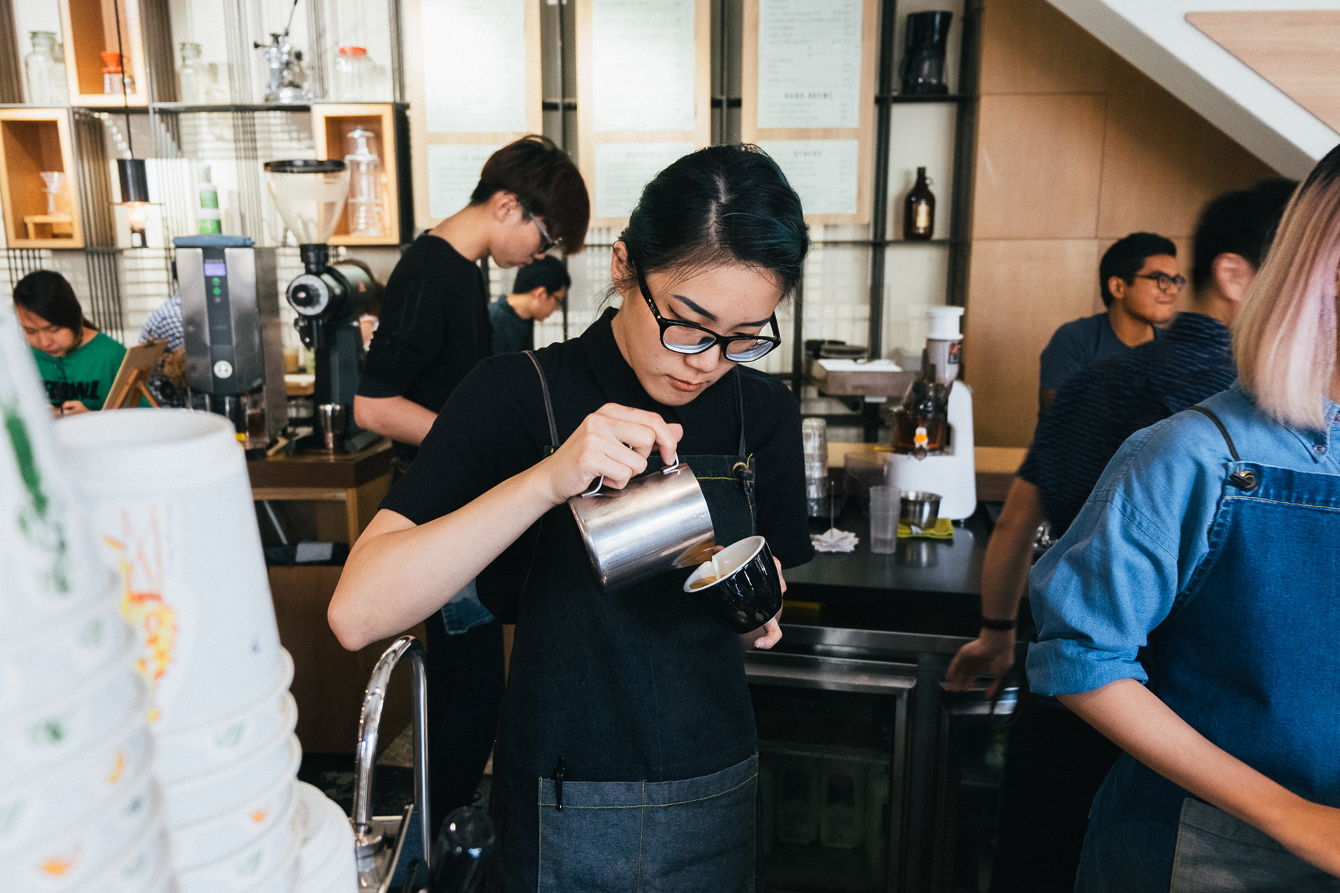 A barista is making a hot latte at a cafe in Singapore.