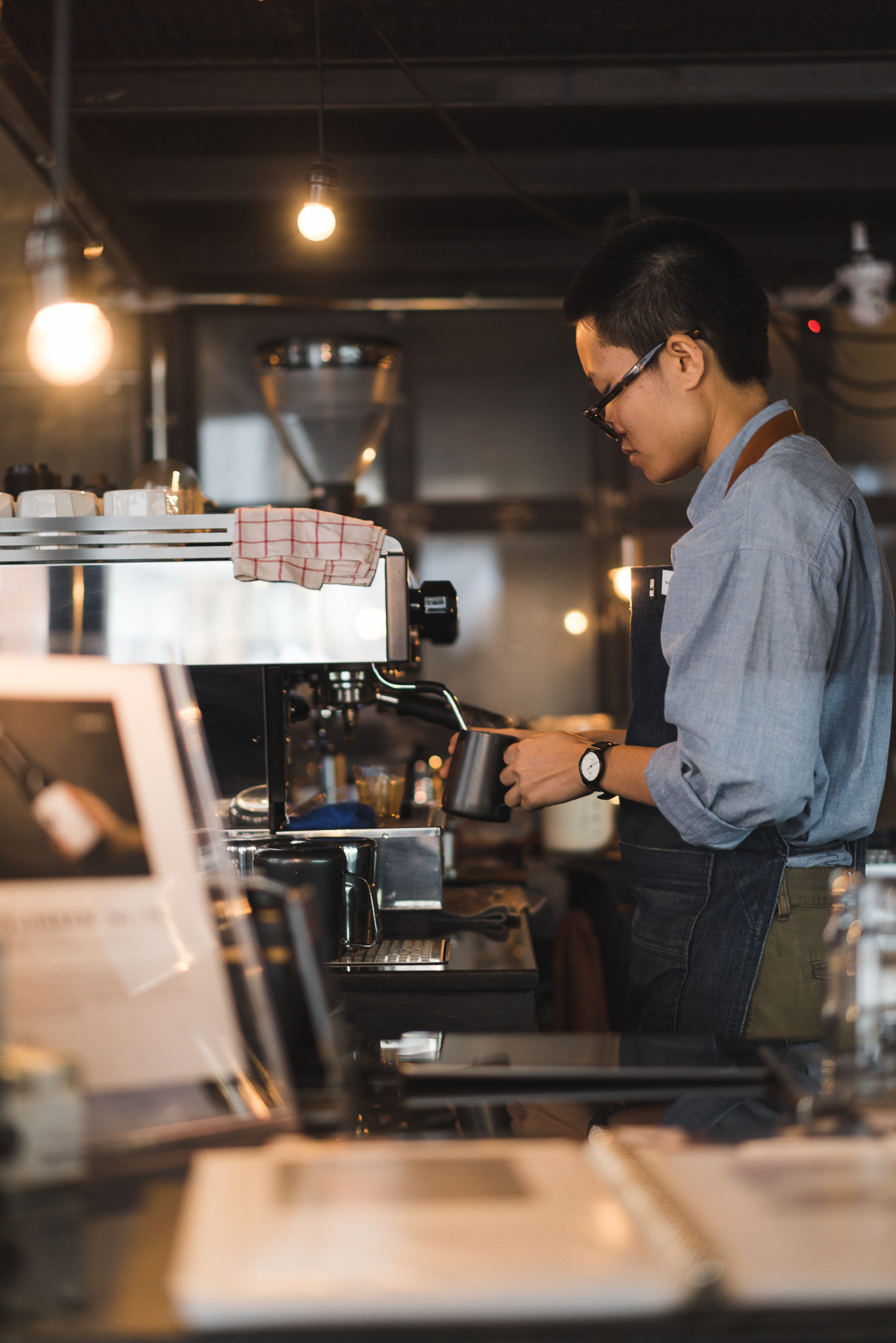 The barista is heating a stream of milk.