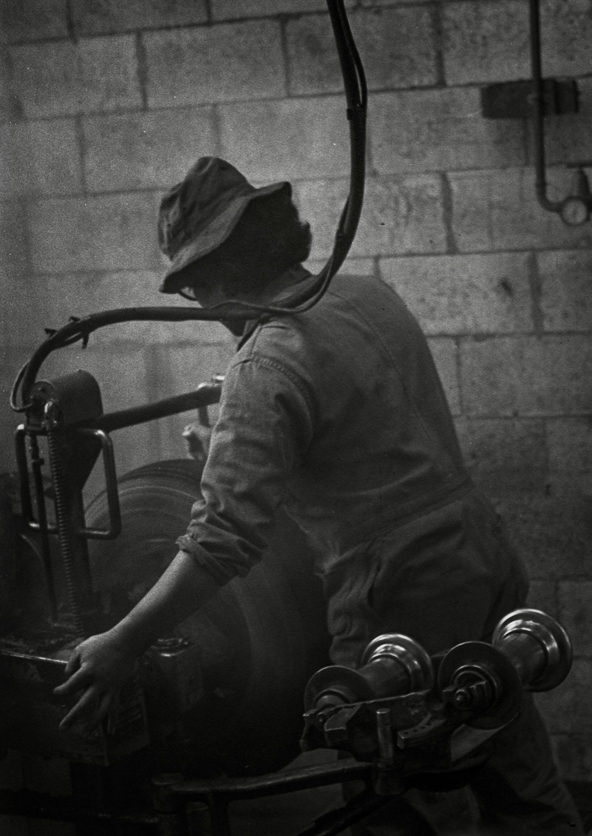 Man at work retreading tyres, Greymouth, West Coast