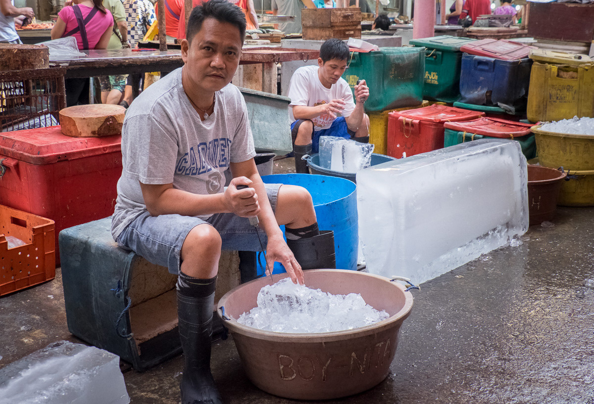 Worker breaking up ice in the wet market area of Marikina Markets, Philippines, 2015