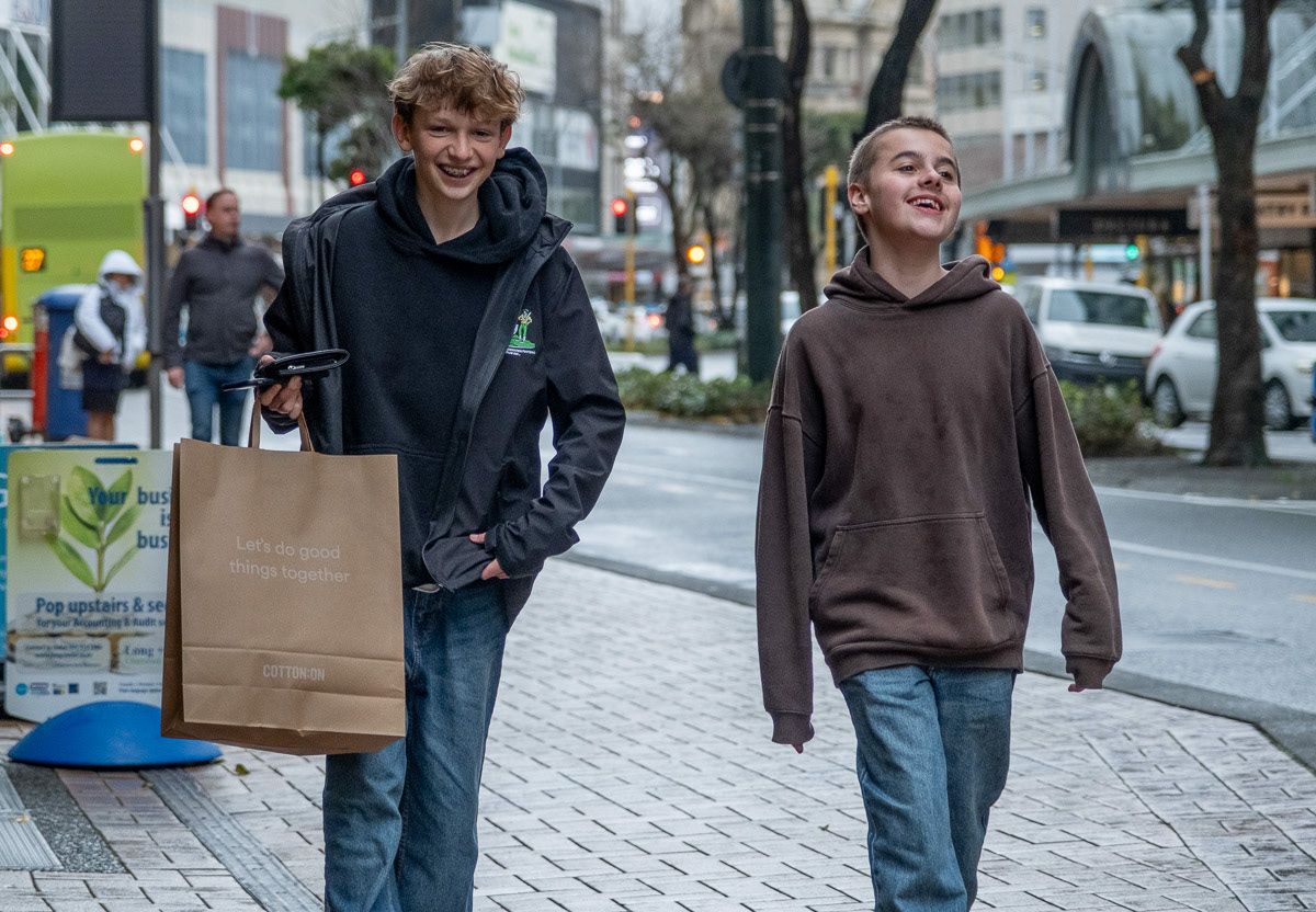 Two smiling boys walking along Lambton Quay, Wellington