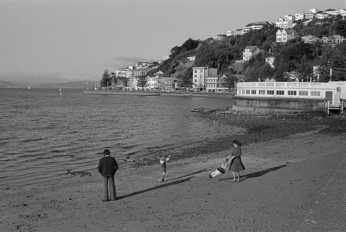 Family on the beach at Oriental Bay, Wellington beside band rotunda