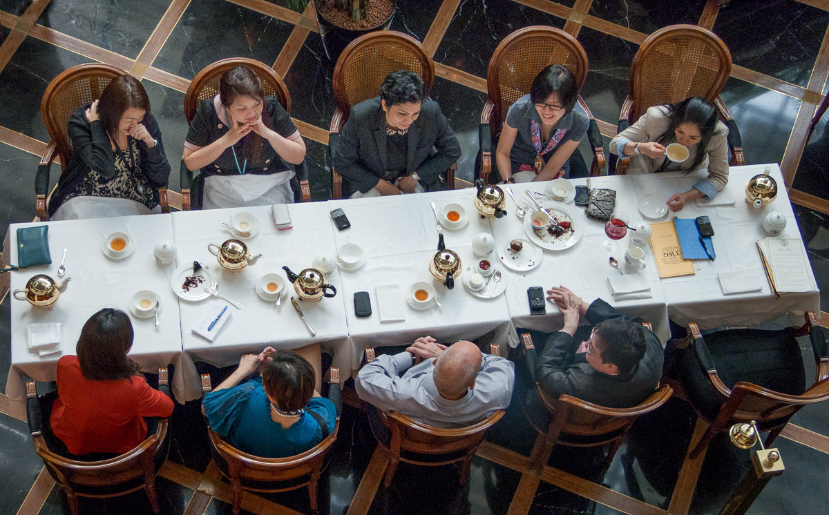 Group sitting round table taking tea, Tea time, Marina Bay Sands, Singapore, 2013