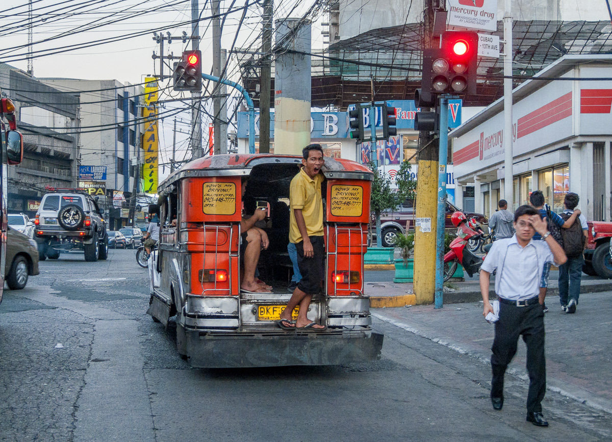 Barker calling for customers from rear of a jeepney in Cubau, Philippines, 2013
