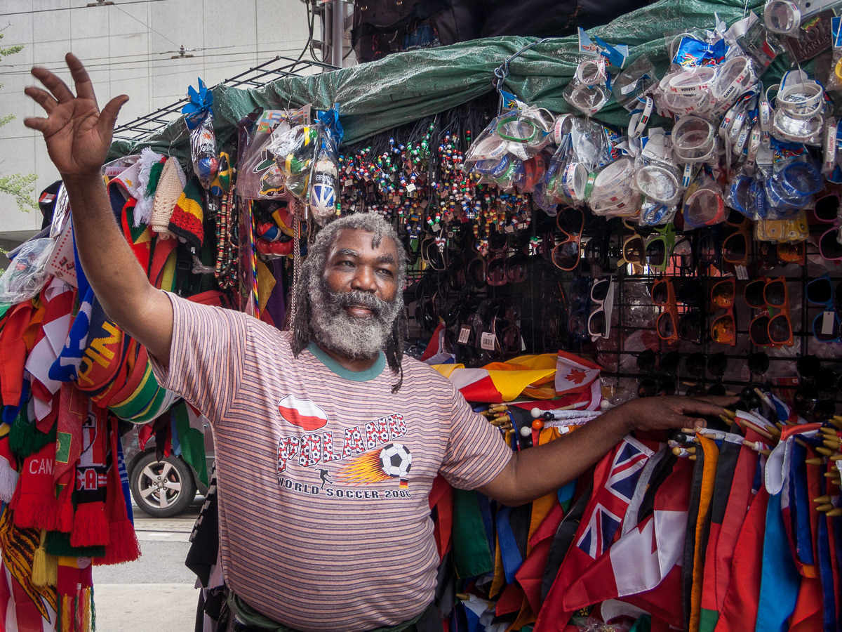 Man from Tobago at his street stall, selling flags and other goods, Toronto, 2011