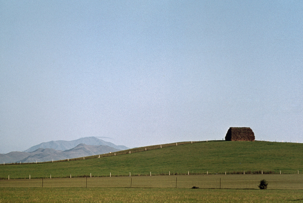 Haystack on hill with Hokonui Mountains in distance