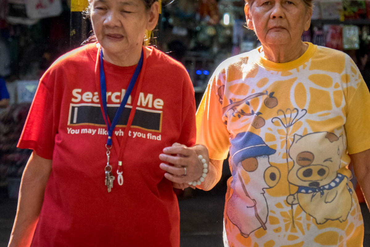 Two women, one with Search me you might like what you find on her clothing, Marikina Markets, Philippines, 2015