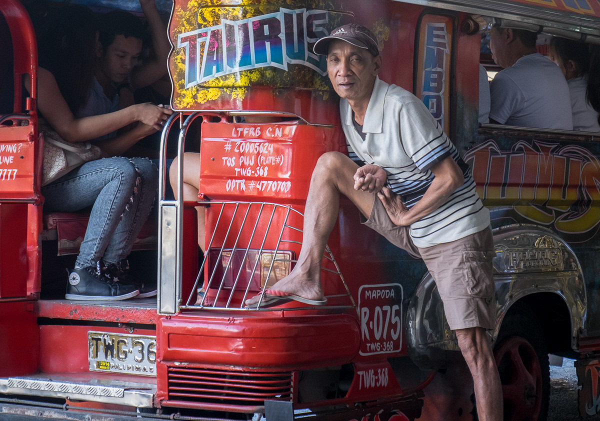 Barker at rear of jeepney, opposite the Marikina Markets, Philippines, 2015