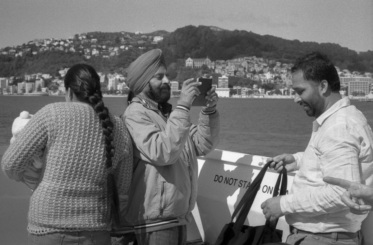 Family on the East West Ferry, heading to Days Bay, 2016, with Oriental Bay and Mount Victoria beyond, Wellington, 2016