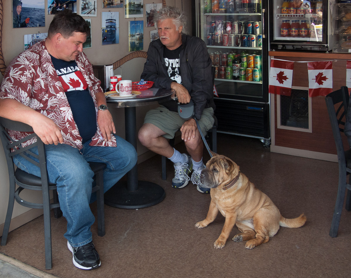 Two men and a dog in a cafe at Steveston Salmon Festival, Canada Day, 2011