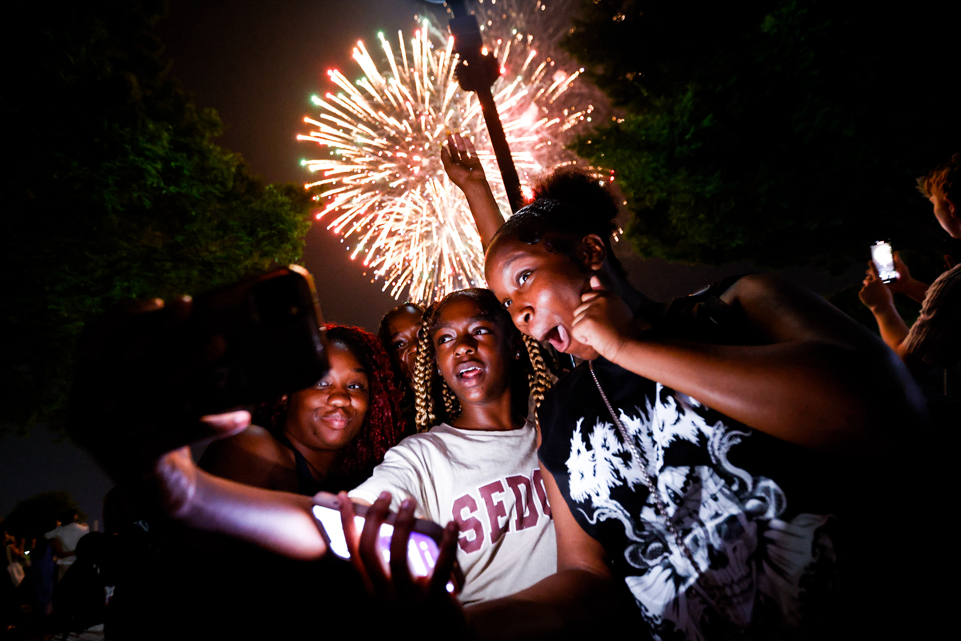 From left, Kansas Frazier-Smith, Rainy Faulk, Mahogane Faulk, 11, and My’Precious Faulk, 14, take a selfie during the fireworks show at Town Point Park in Norfolk, Virginia, on July 4, 2024.