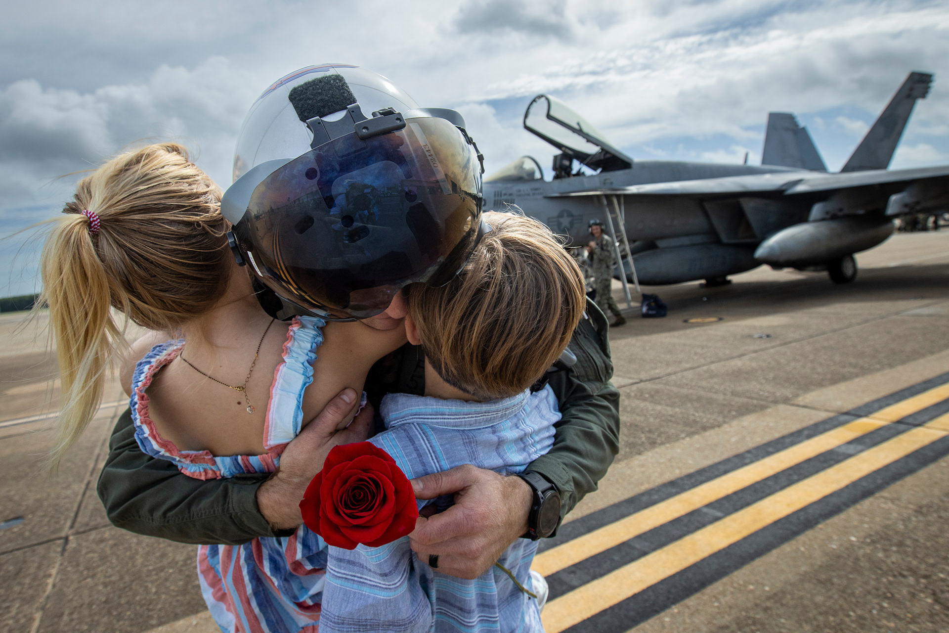 Commander Andrew “Sugar” Stoner embraces his daughter Katherine Stoner, 7, and son Ellis Stoner, 10, after returning to NAS Oceana in Virginia Beach, Virginia, on July 12, 2024. The pilots returned after a nine-month combat deployment to U.S. 5th and 6th Fleet areas of operation.