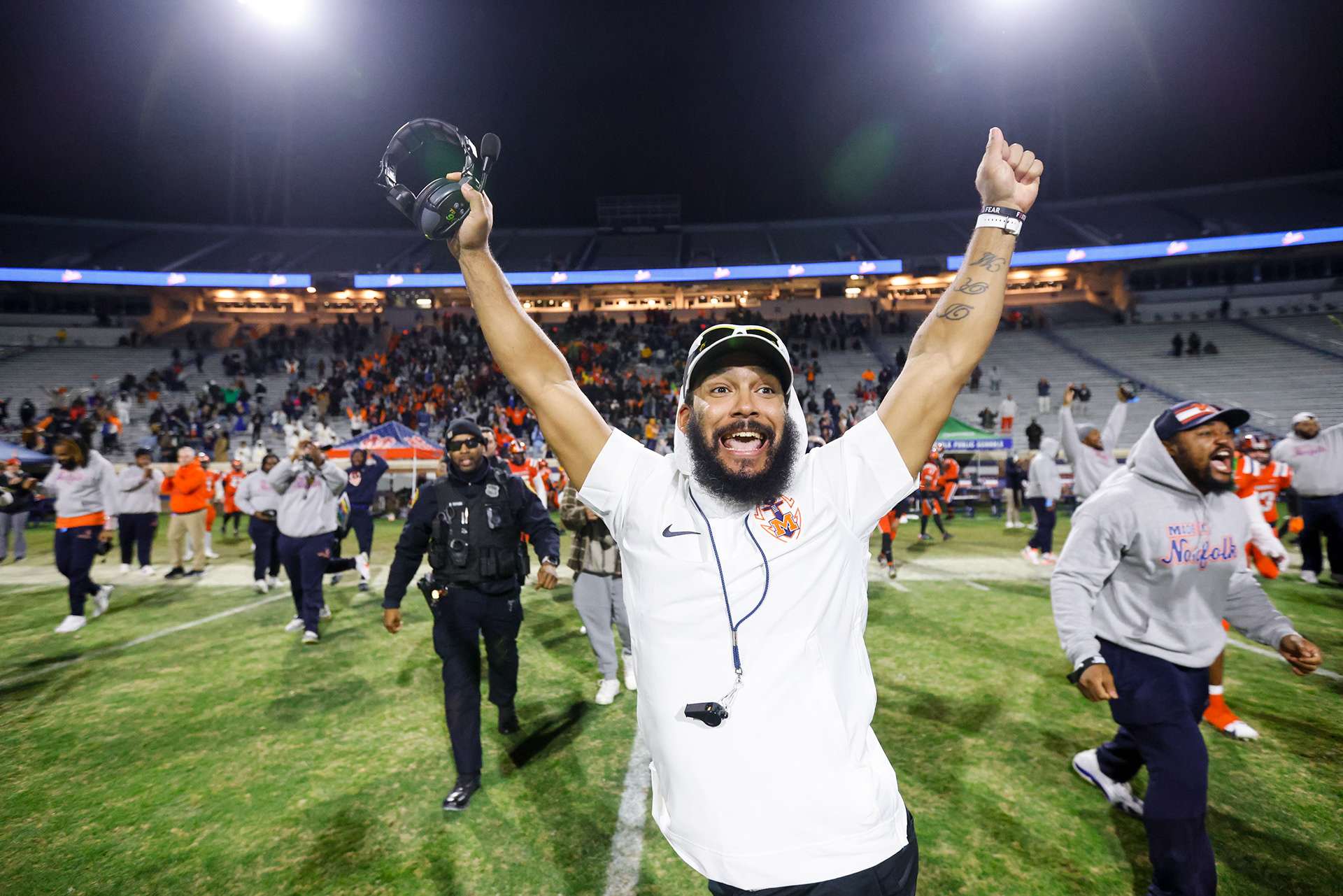 Maury head coach Dyrri McCain throws his arms into the air to celebrate defeating Stone Bridge 45-34 in the class 5 state championship at Scott Stadium in Charlottesville, Virginia on Dec. 9, 2023.
