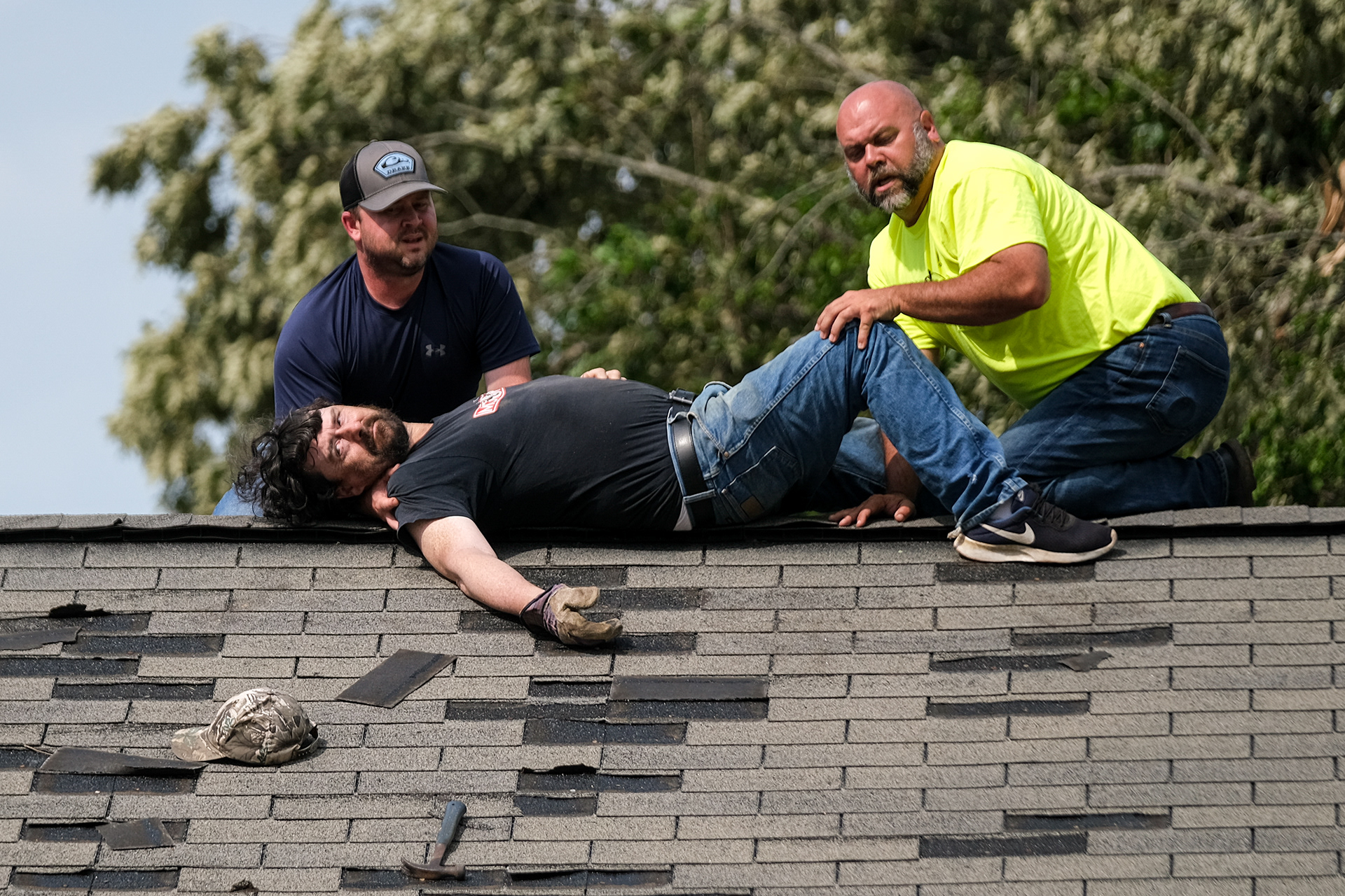 A worker lays on the roof in after suffering from a heat stroke while working on roofing repairs. Tornados left significant damage across Tupelo, Mississippi on May 2, 2021 and left thousands without power.
