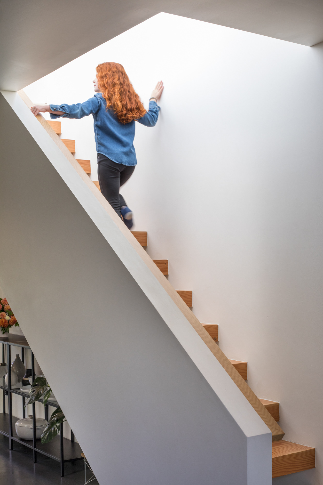 A minimal, open staircase leads to the second floor.