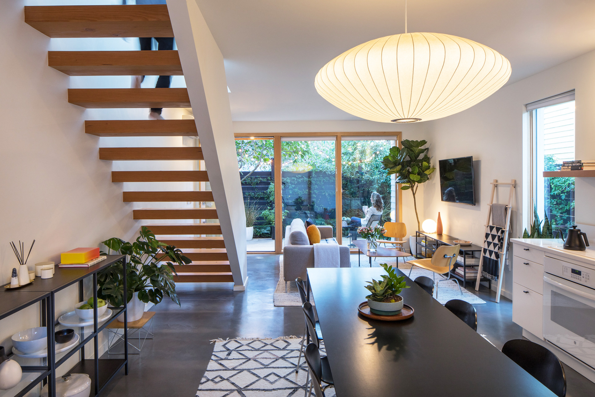 The open ground floor features a living space, dining space, kitchen and open staircase.