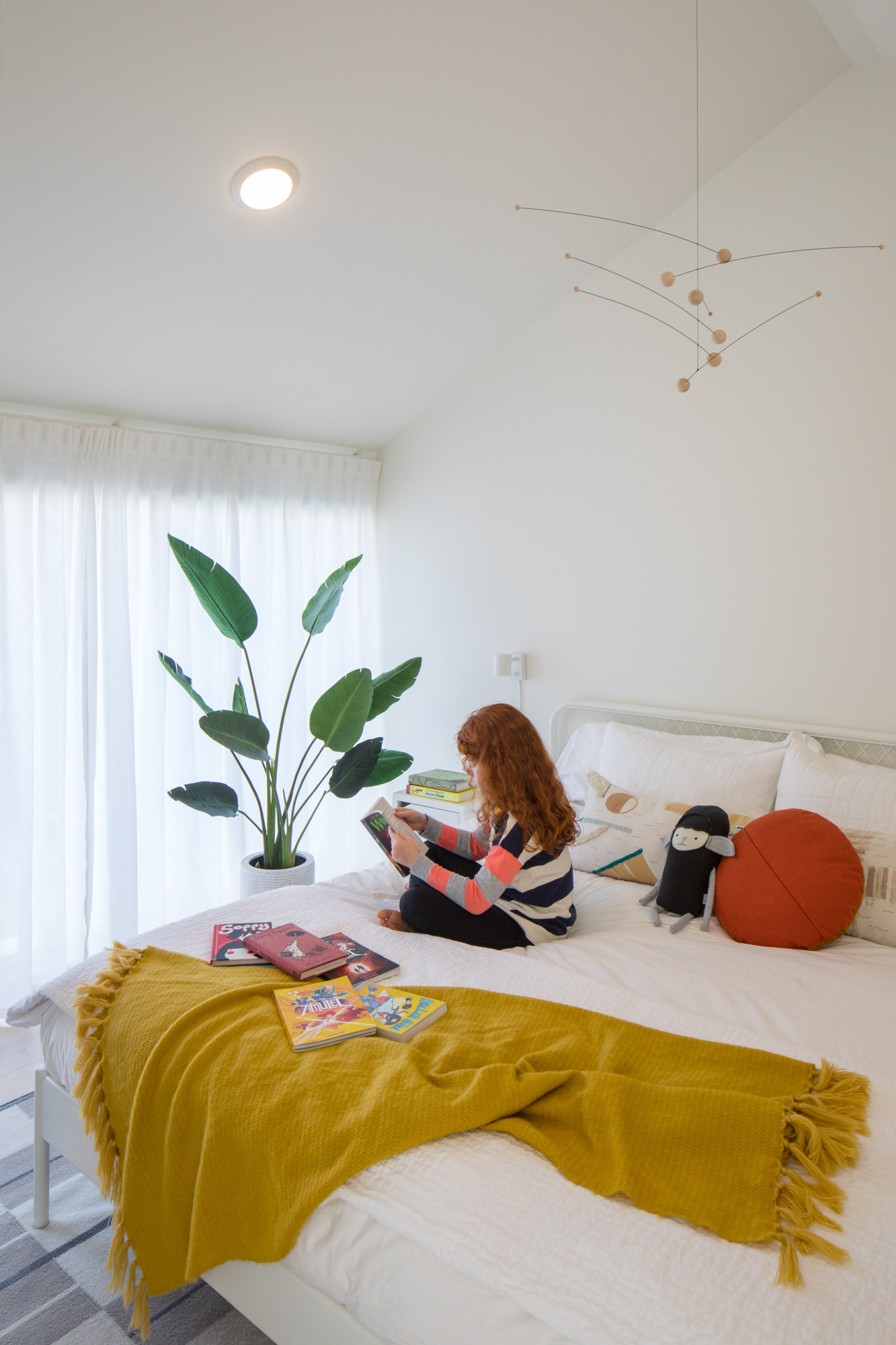 A modern mobile hangs over the bed in the front bedroom.