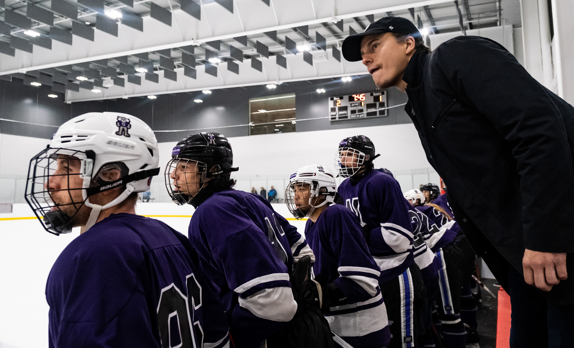Members of the Northwestern club hockey team lean against the side of the rink to watch the their teammates play against Purdue Northwest in Evanston, Illinois on October 29, 2022. For The Daily Northwestern.
