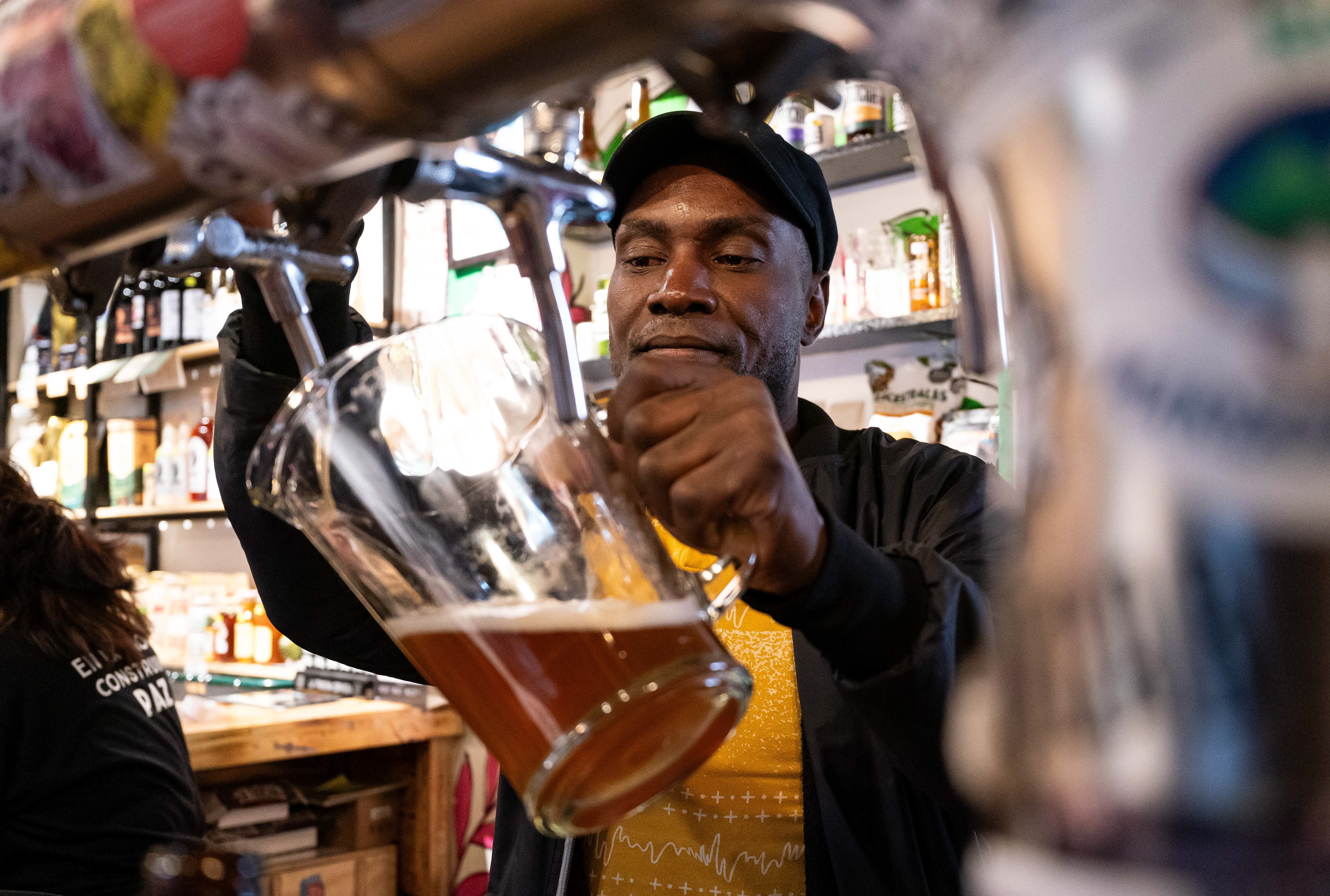 Sebastian Paz, a firmante and brewer at La Casa de la Paz, pours beer from the bar's tap in Bogotá, Colombia on March 22, 2024. Paz brews the cultural house's "La Trocha" (the path) beer brand, and hopes to teach brewing to others as he continues honing his craft.