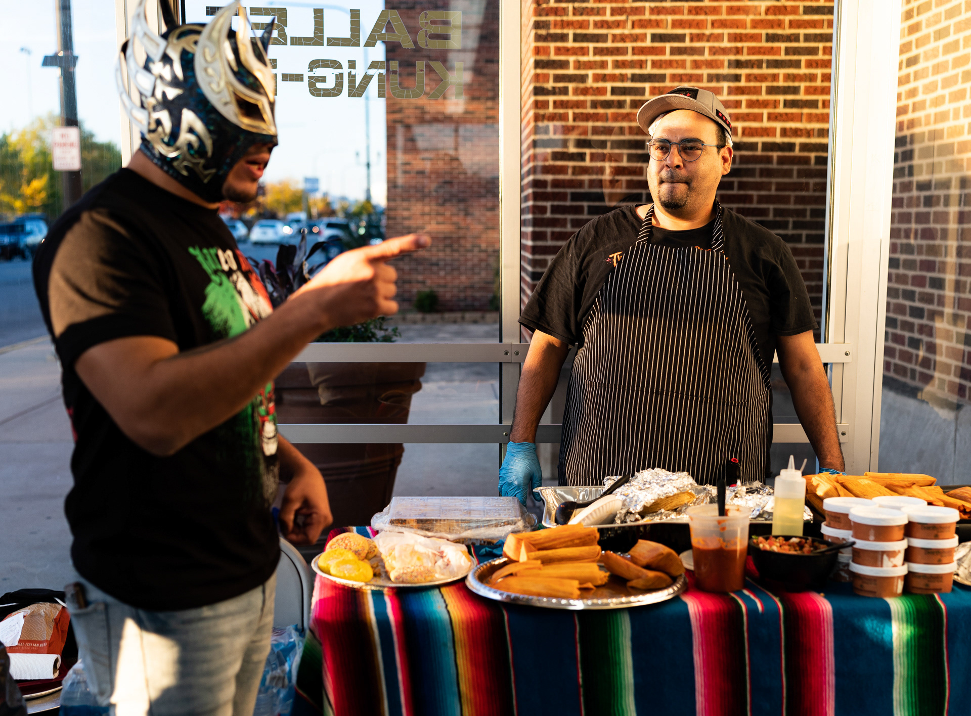 Daniel Cano escucha Laredo Kid mientras sirve comida para una bienvenida con luchadores antes del show de IMPACT Wrestling en Cicero Stadium en Cicero, Illinois el 22 de octubre, 2023.