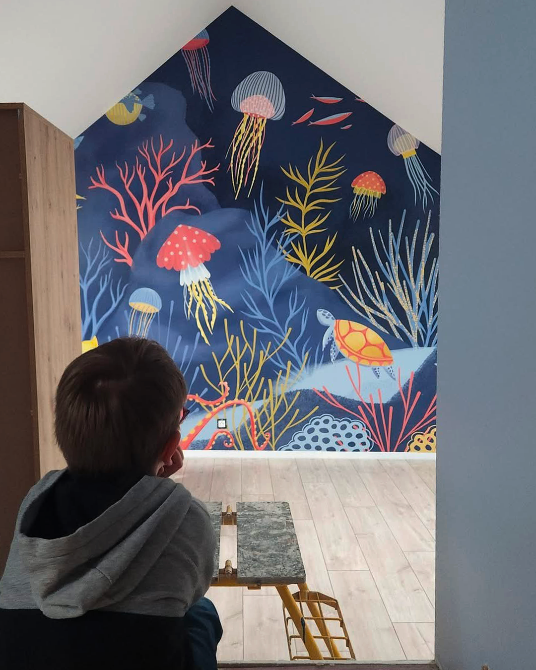 l'enfant qui contemple sa fresque fraichement installée