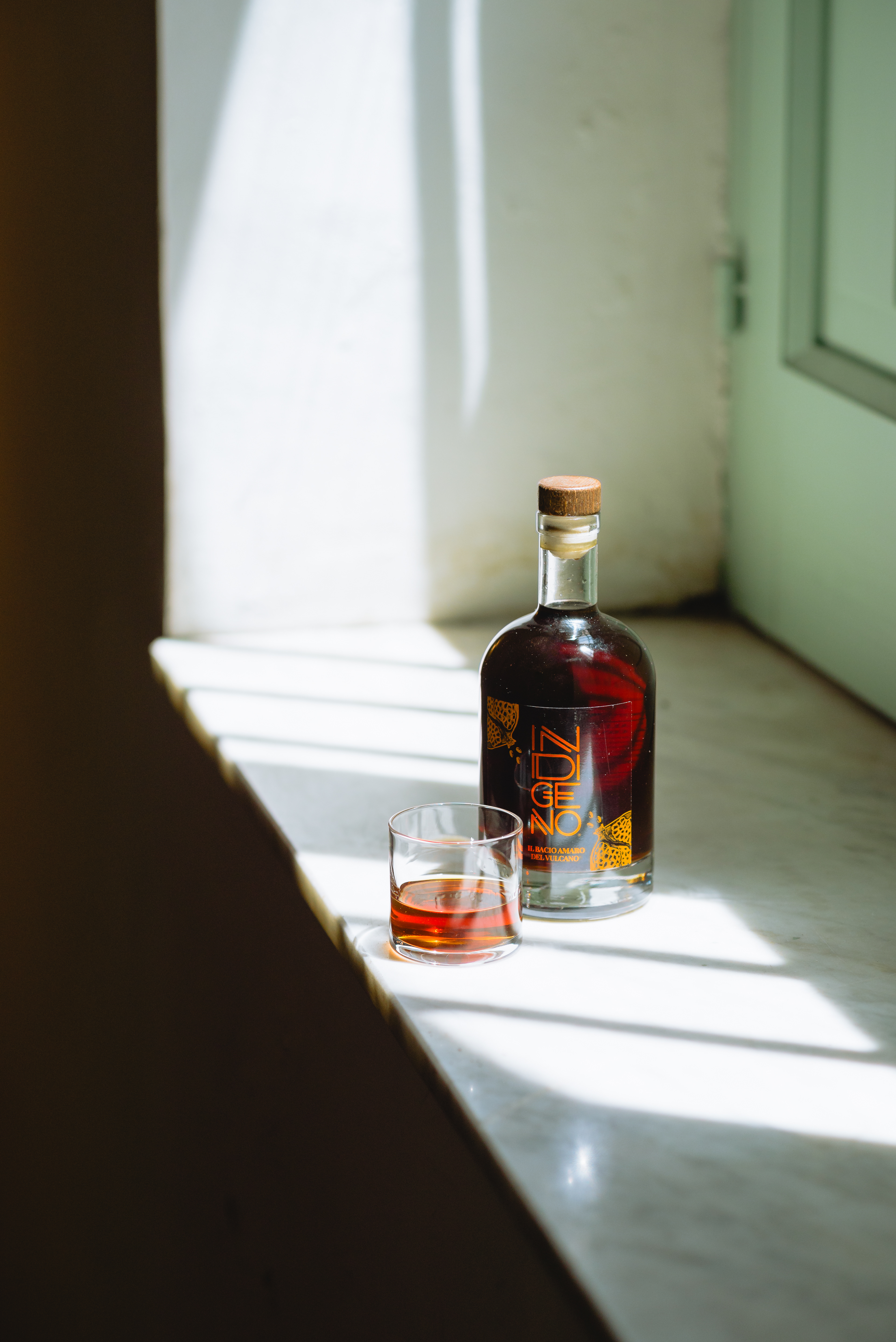 Liquor photography Amaro Indigeno - Bottle product lighting professionale narrativo.