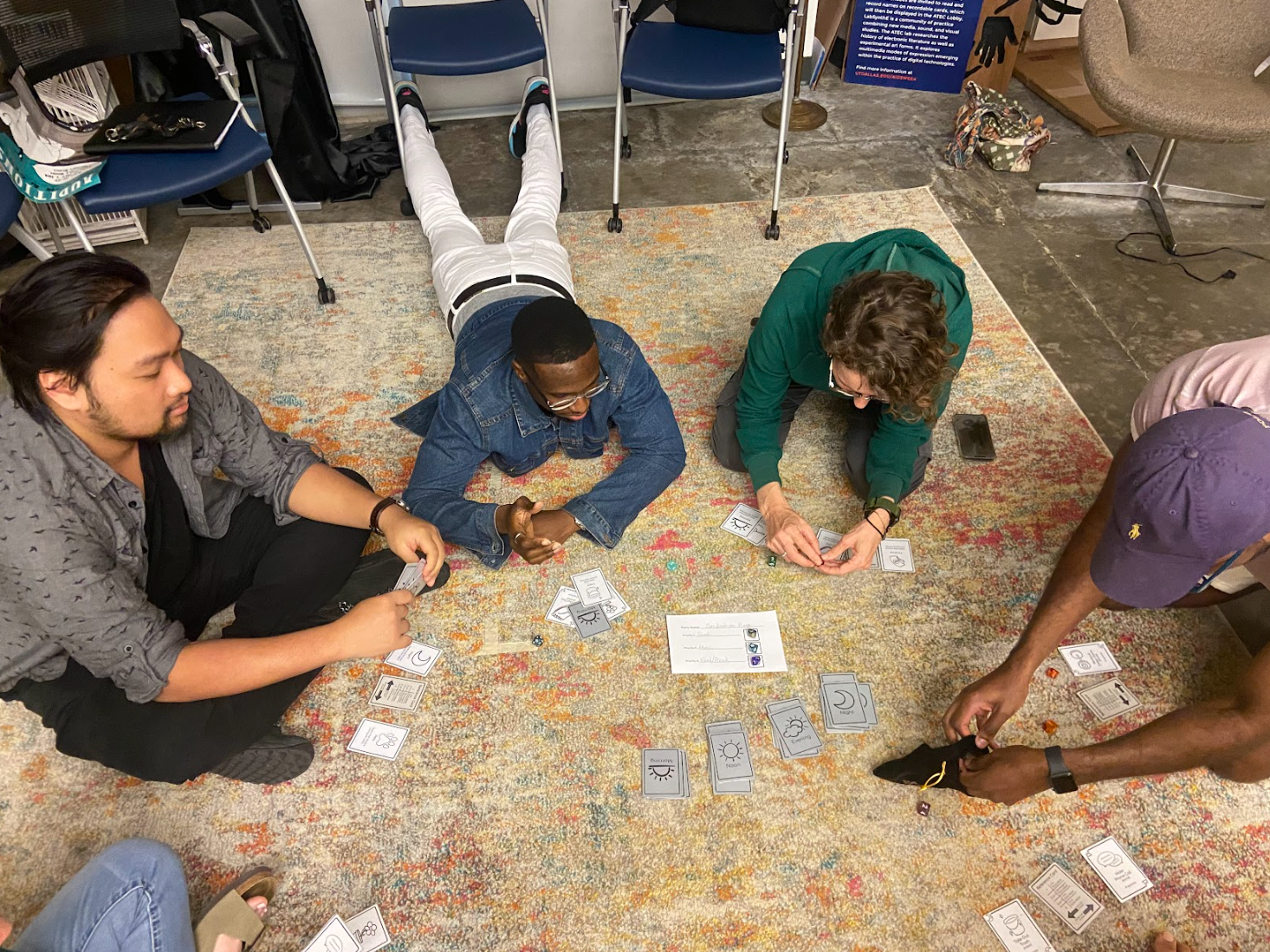 Four players sit on a rug determining their team goals for the start of the game.