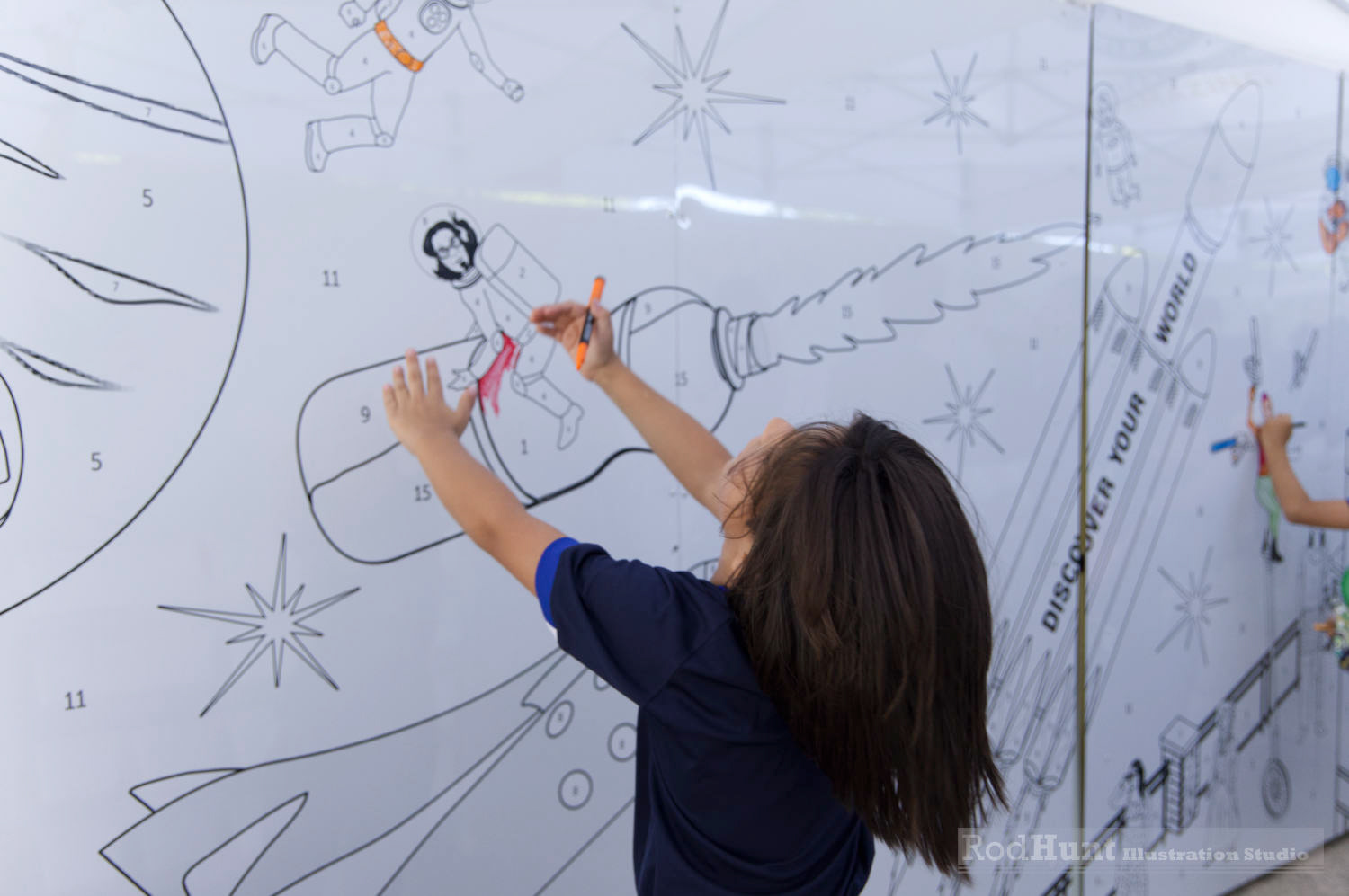 Children colouring a black an white line illustration printed wall mural installation