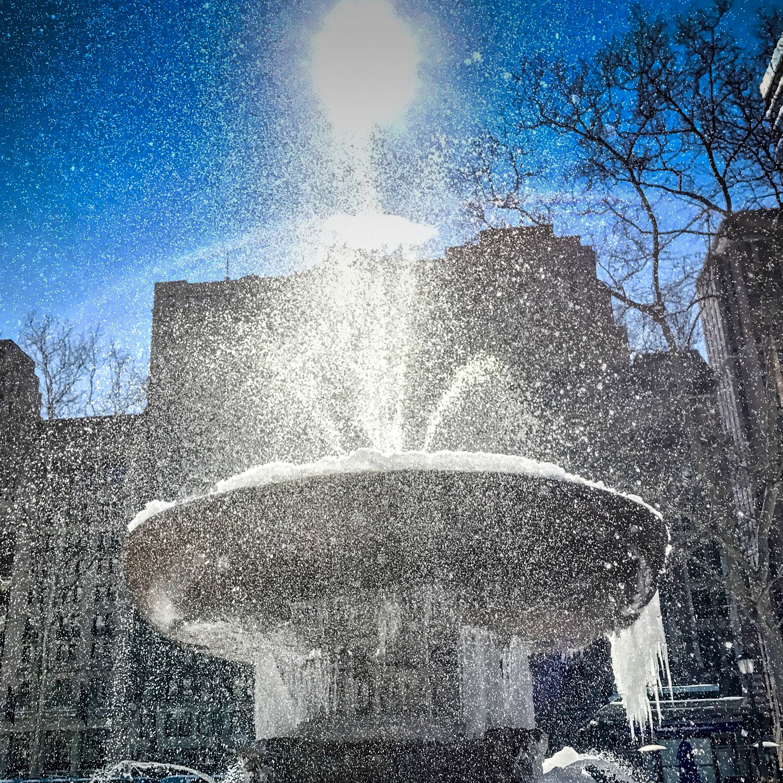 Water spraying from a frozen Bryant Park fountain, New York