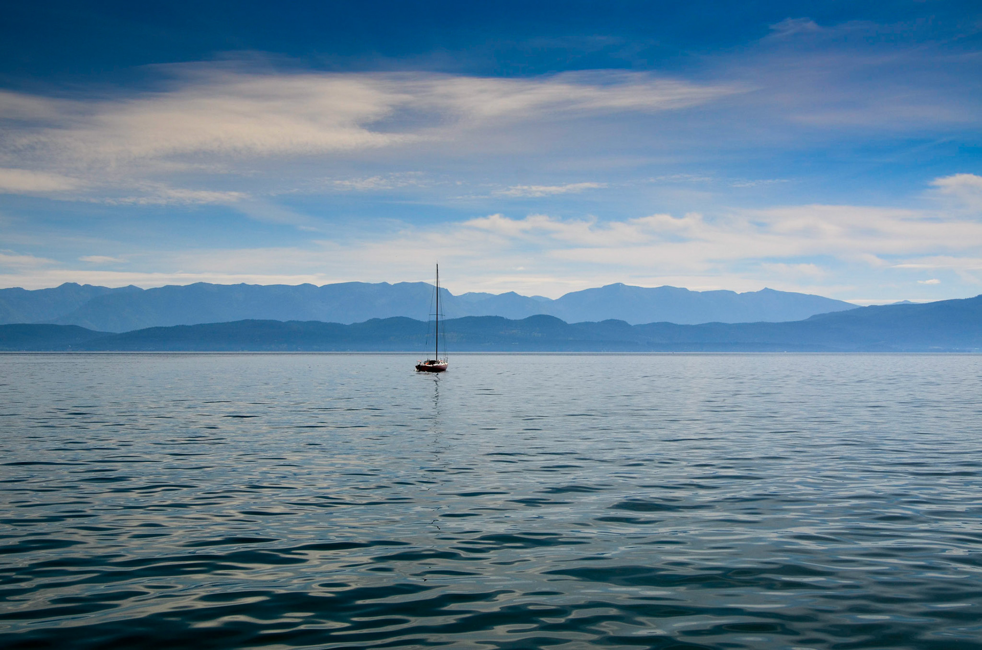 Boat on Flathead Lake with mountains in the distance, taken from Lakeside, Montana