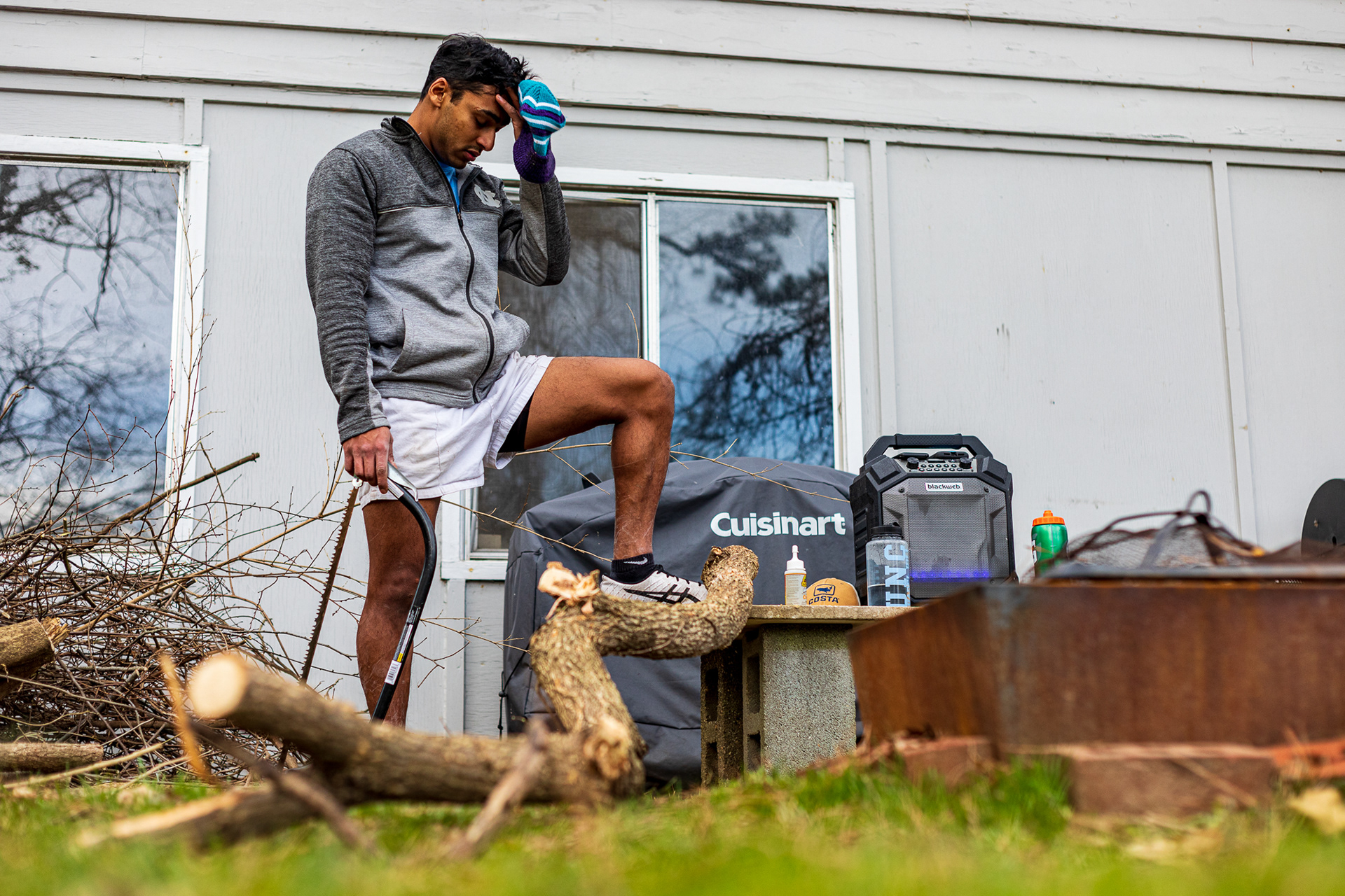 Patel takes a break from cutting wood that will soon be burned in the firepit in the corner.