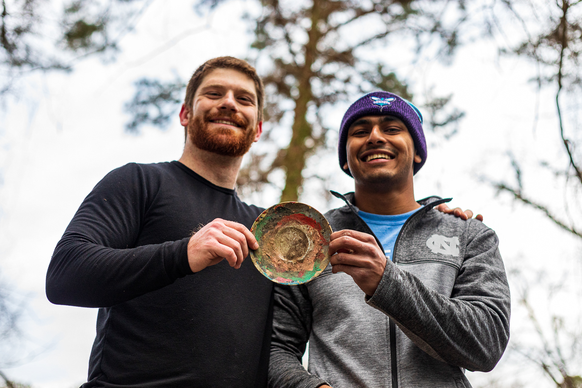 Patterson and Patel pose with a plate they found in the yard of their home on Jan. 30, 2021. The plate, covered in dense splotches of paint, may have been used as a paint palette by the Allcotts.