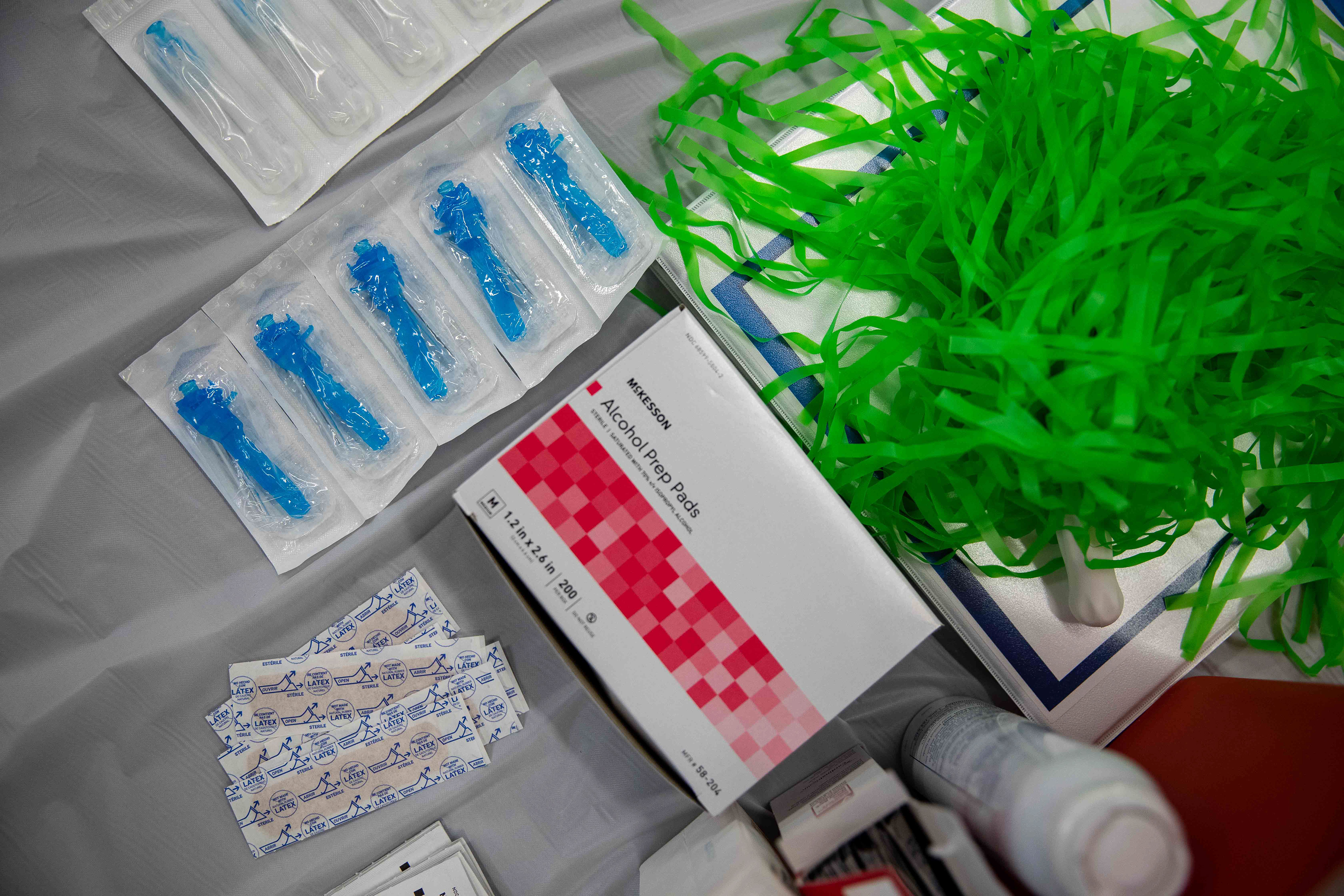 Supplies for administering the coronavirus vaccine lie ready at a station at the vaccination clinic. Among the supplies is a pom-pom for celebrating the vaccinations.