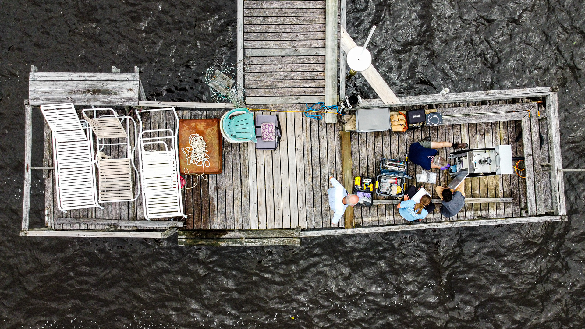 Volunteers from the CEEG help IMS researchers install a water monitoring device near Edenton, N.C., June 11, 2020. The device is set up on the dock of a local volunteer who loans the space to researchers every summer.