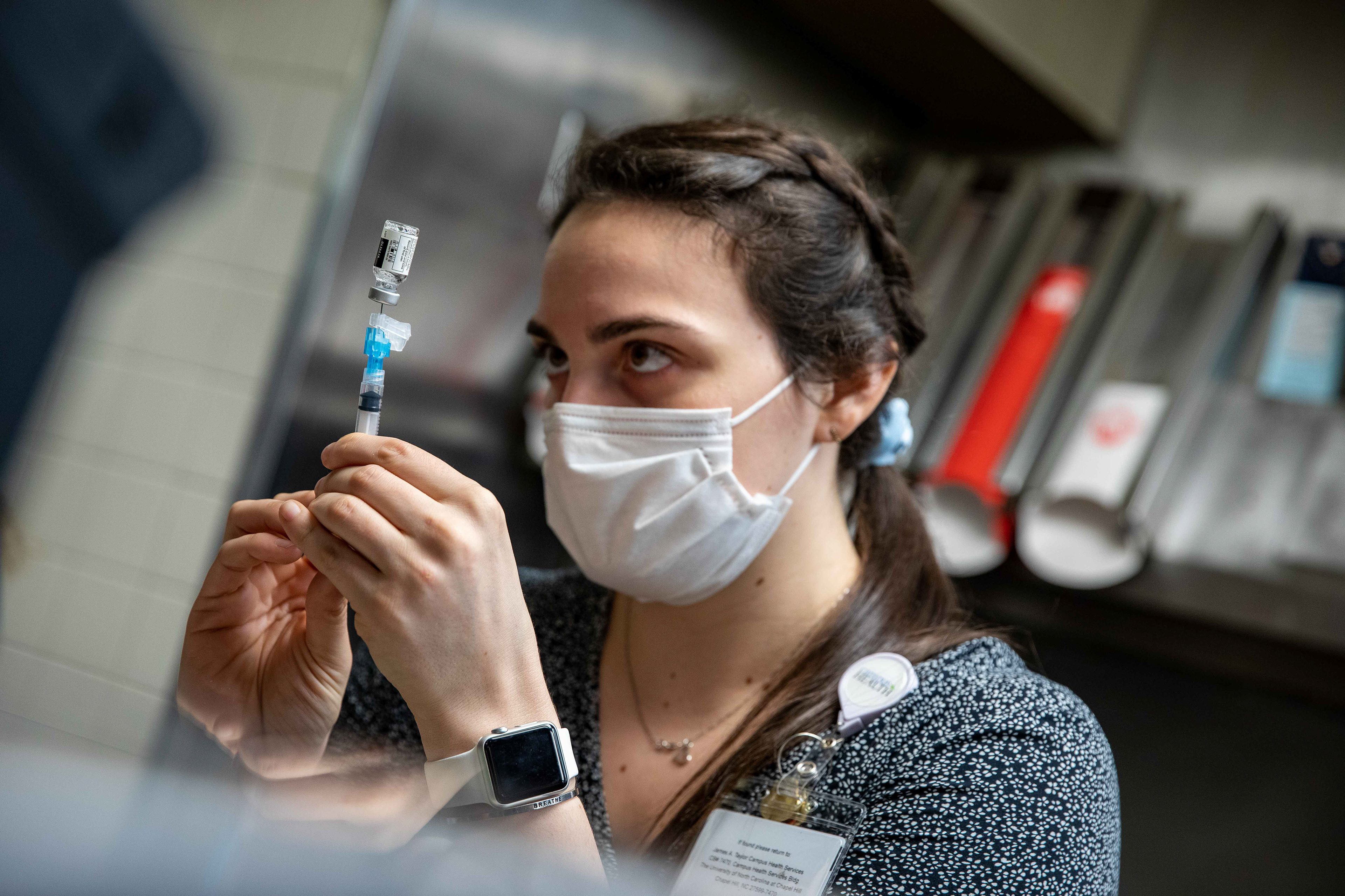 A UNC pharmacist prepares a vaccine dose in the kitchen of the former Wendy’s in the Student Union at UNC in Chapel Hill, N.C., March 31, 2021. Old unused fry containers still remain from the Wendy’s that closed at the beginning of the pandemic.