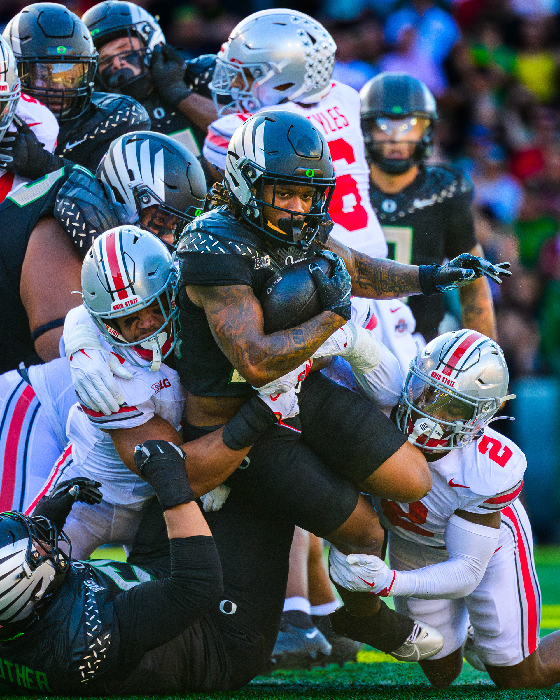 Oregon Ducks running back Jordan James, #20, fights through contact for extra yardage after initial contact from Ohio State defenders while being pushed forward by members of the Oregon offensive line. James, who accounted for 121 yards of offense and a touchdown, was Oregon's leading rusher in their win over the Ohio State Buckeyes 32-31 on Saturday, October 12, 2024.