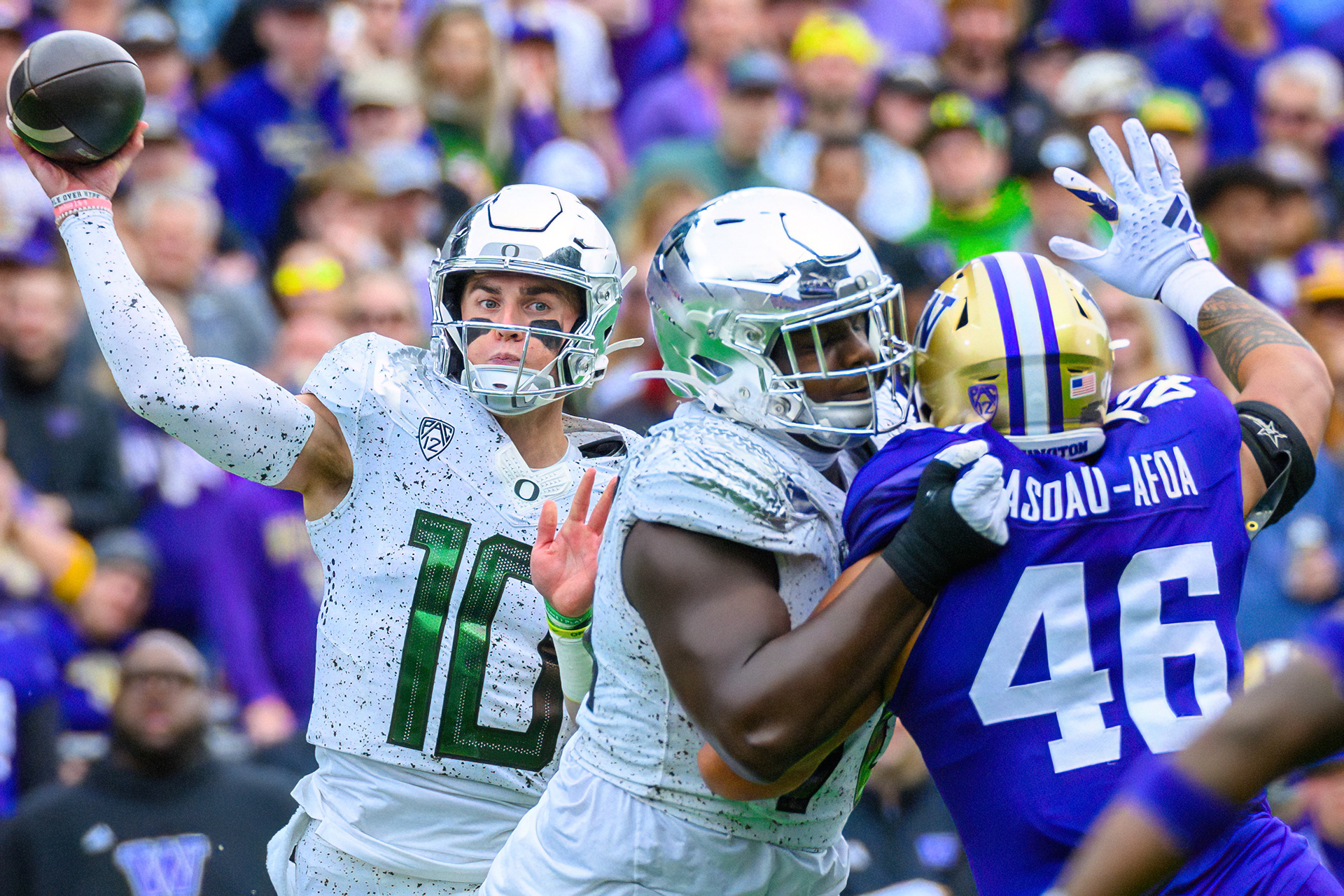 Oregon Ducks quarterback Bo Nix (10) throws while under pressure from Washington Huskies defensive lineman Sekai Asoau-Afoa (46) during a game against the University of Washington Huskies at Husky Stadium in Seattle, Wash., on Oct. 14, 2023.  Nix passed for 337 yards and two touchdowns in the 36-33 loss to the Huskies.