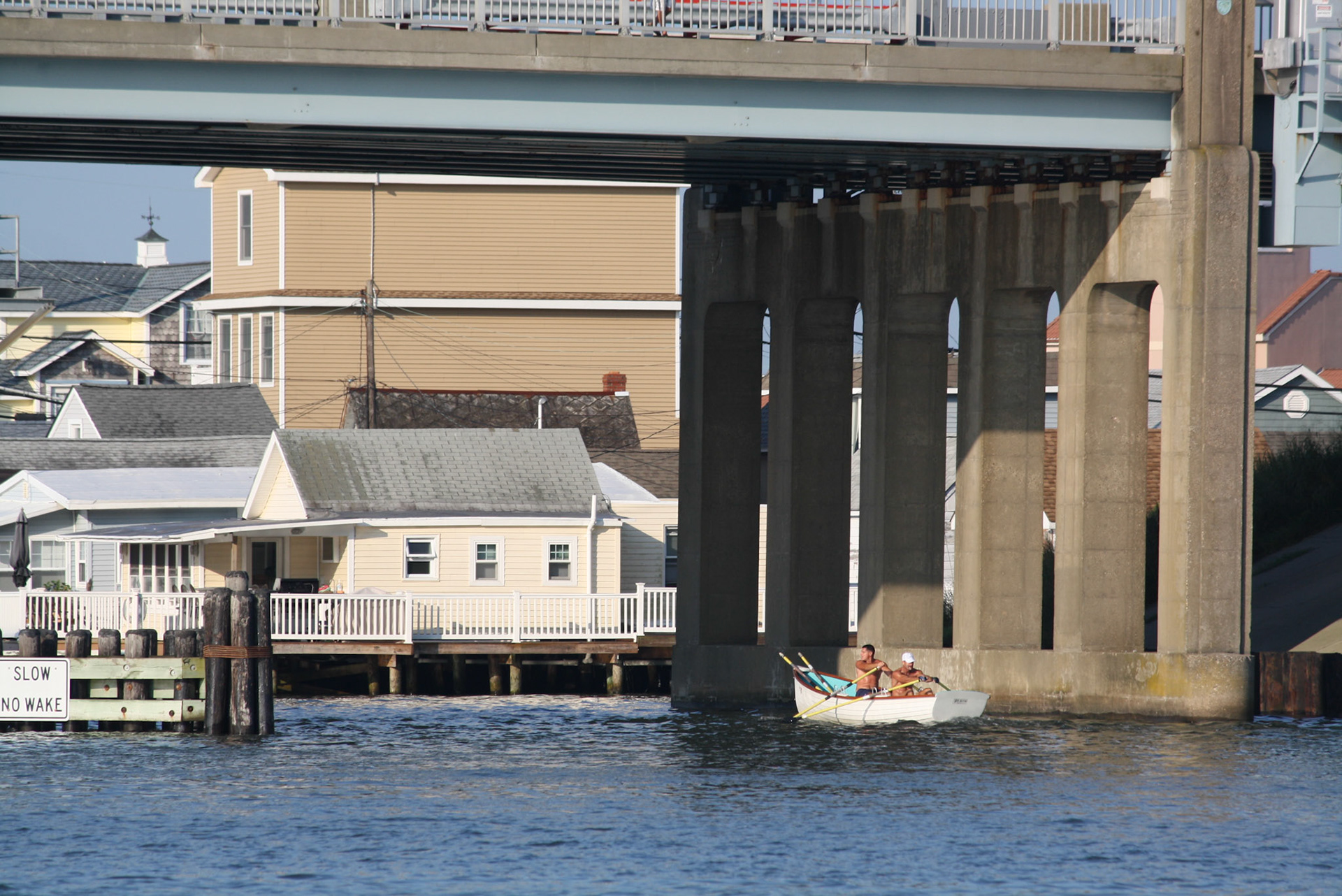 Lifeguards row beneath the Rio Grande Ave. bridge during Around the Island Row competition