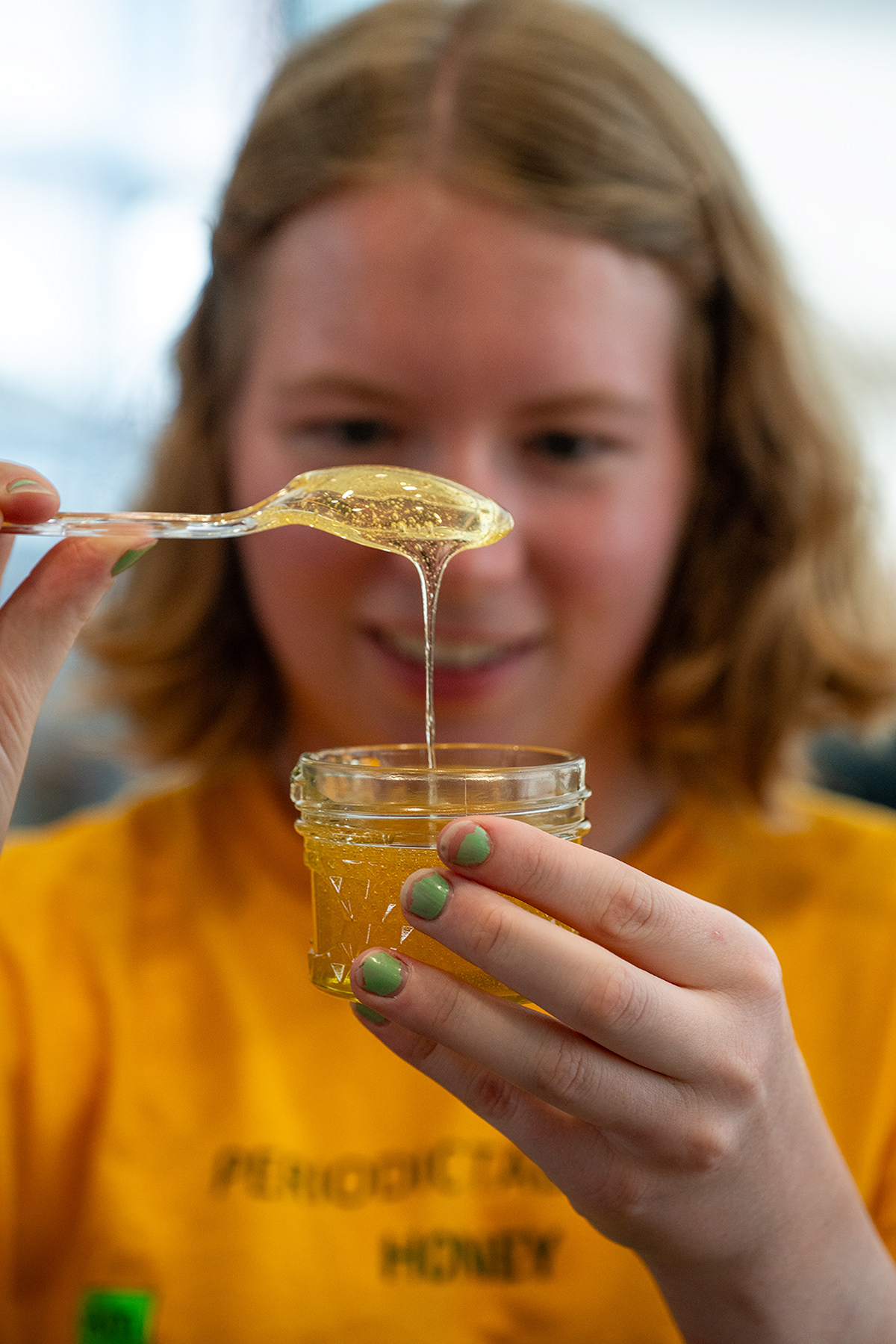Ellie Warren the president of the RIT beekeeper club inspects the final product of the annual honey harvest, in Henrietta, NY Sept. 3, 2023.