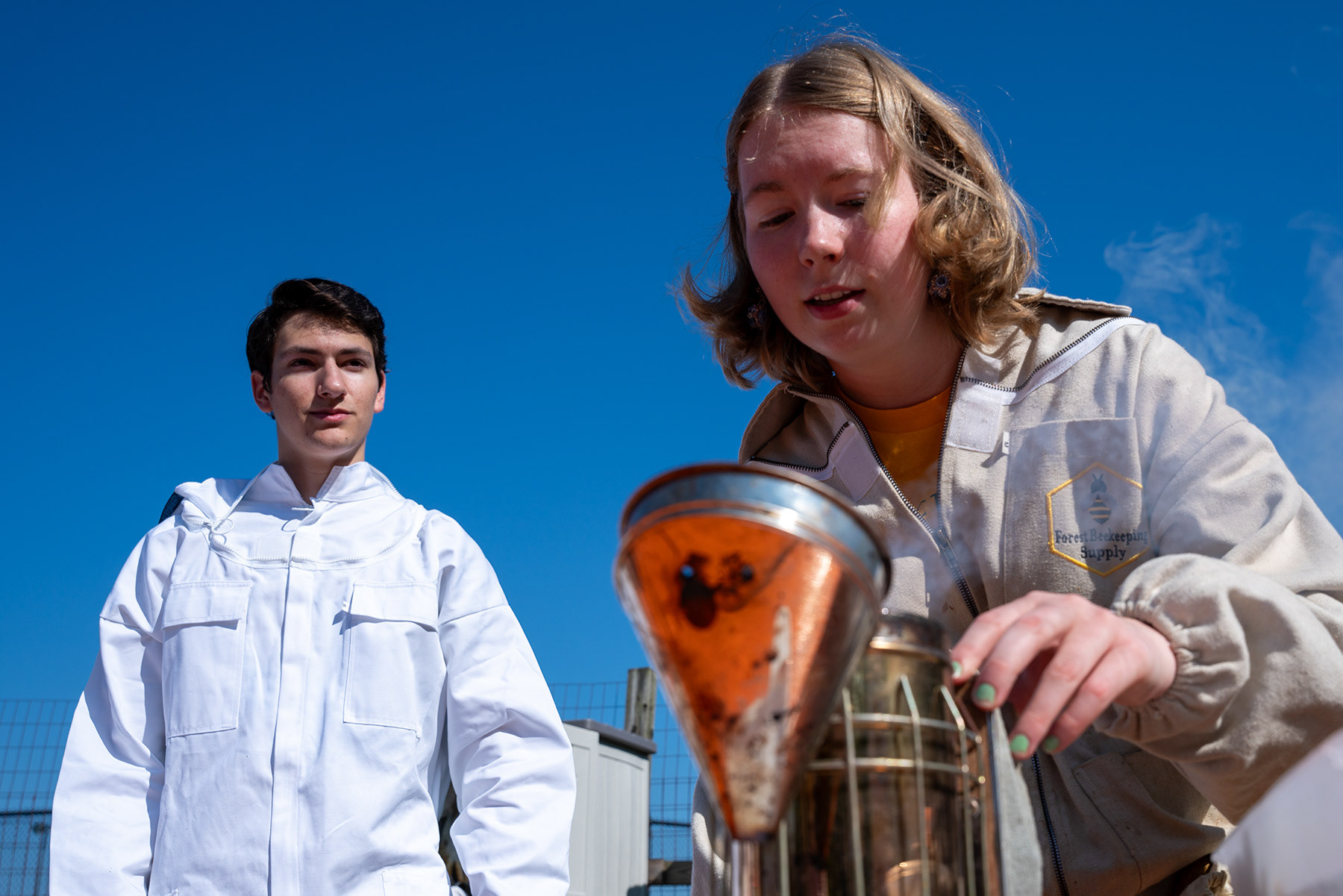Ellie Warren, Daniel Bossett, prepare the bee hive smoker on Sunday, Sept. 3, 2023, at  Henrietta, NY.  Smoke is used to both calm the bees and get them to move where the keeper wishes often off of frames that will be handled.  
