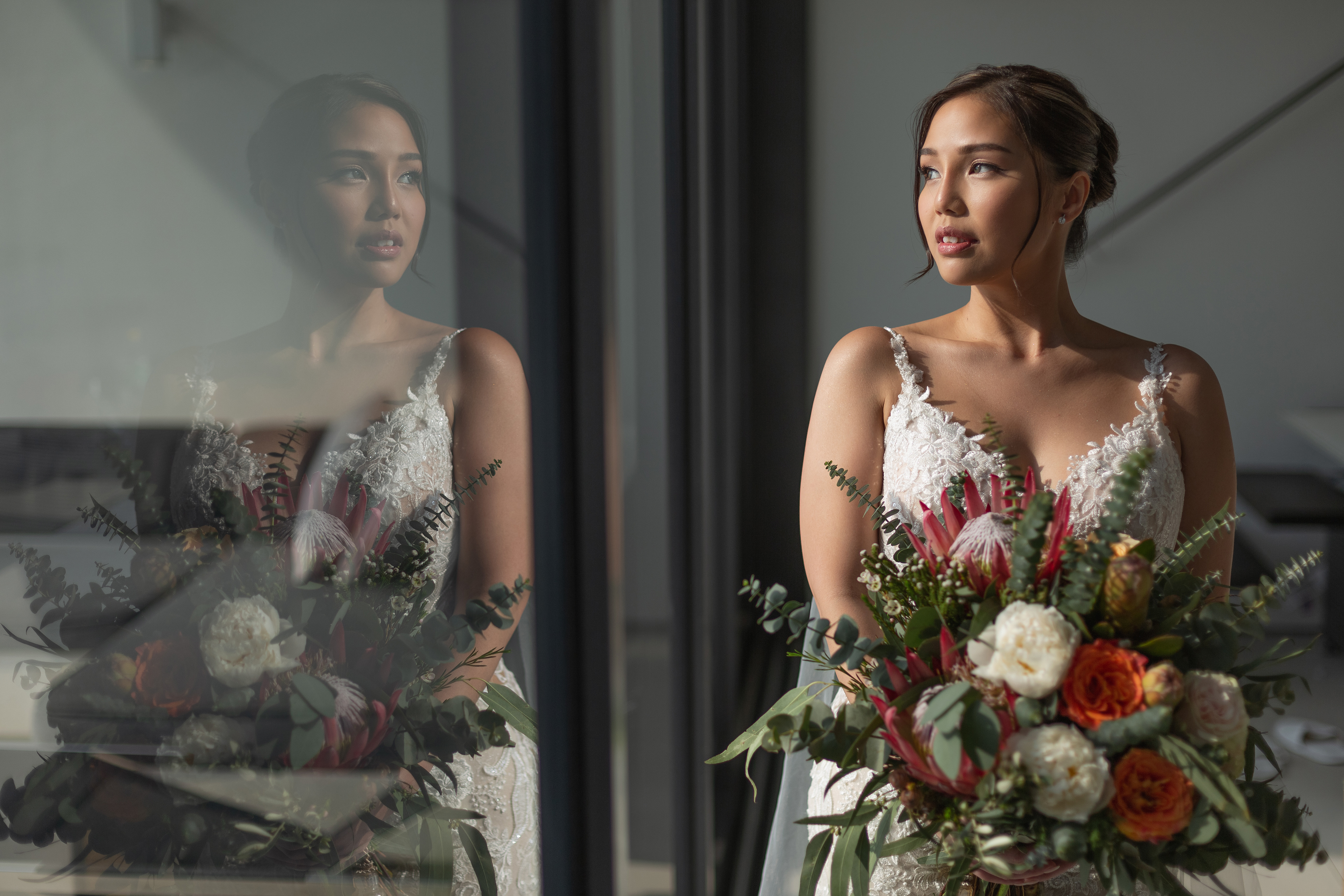 Beautiful bride holding her flower bouquet looking out of window to the view of sea in Phuket. Phuket Krabi Samui Phang nga Thailand wedding photographer photographing wedding photography of a beautiful beach wedding