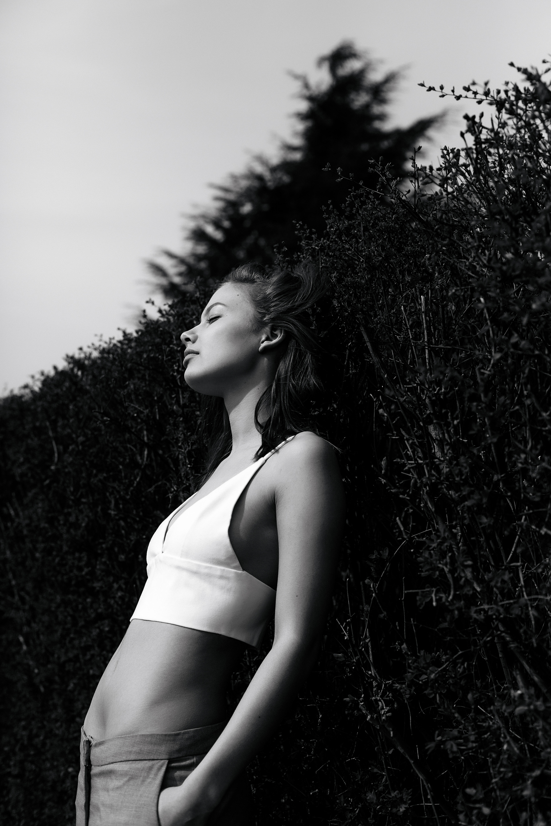 Portrait photo of a girl leaning on a bush in Nyborg Denmark
