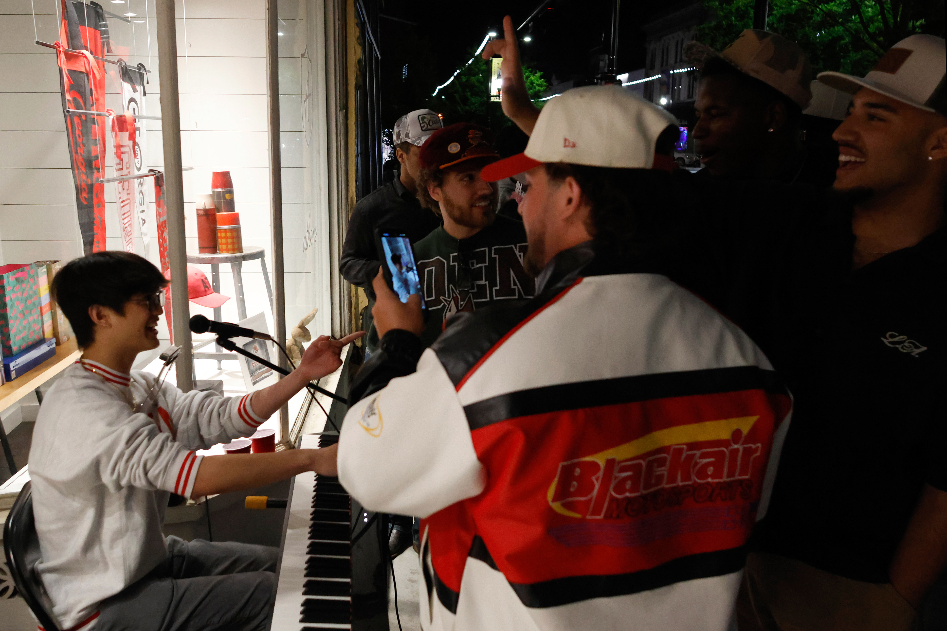 A crowd forms around Andrew Hsu as he plays the piano in downtown Athens, Georgia, on Saturday, April 12, 2025. Hsu always performs in front of Archer Paper Goods.